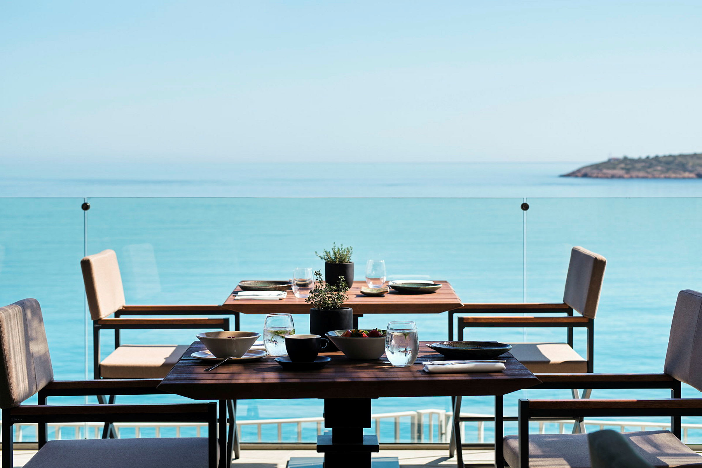 Et dækket bord på en terrasse med udsigt over havet. (AI-genereret tekst)
