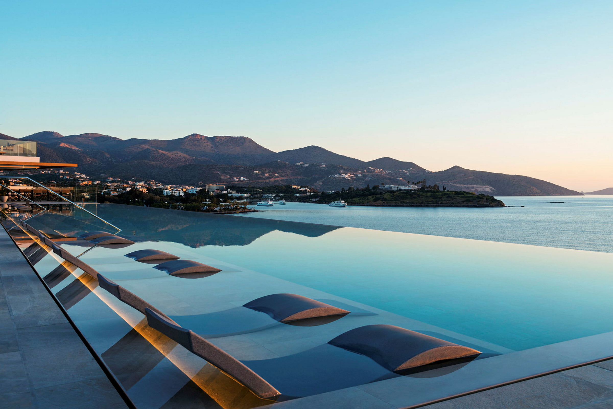 Infinitypool med udsigt over havet og bjerge i baggrunden. (AI-genereret tekst)