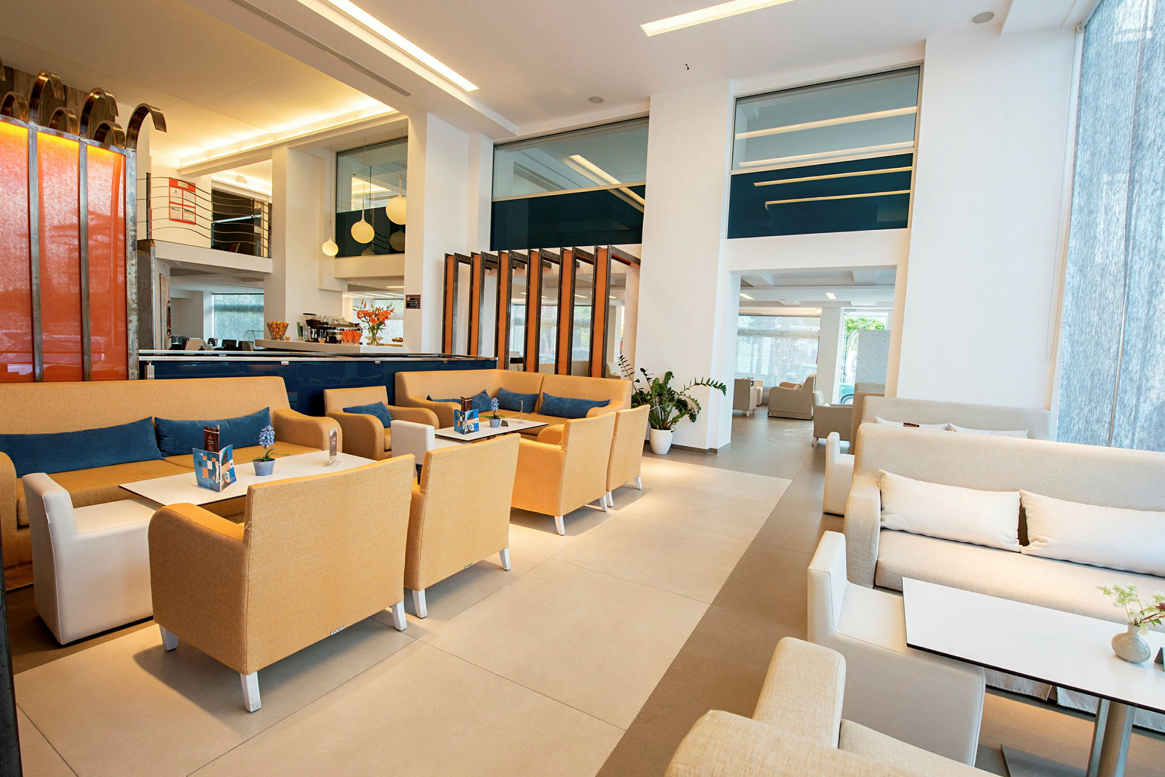 Hotellobby med siddegrupper, borde og moderne indretning. (AI-genereret tekst)