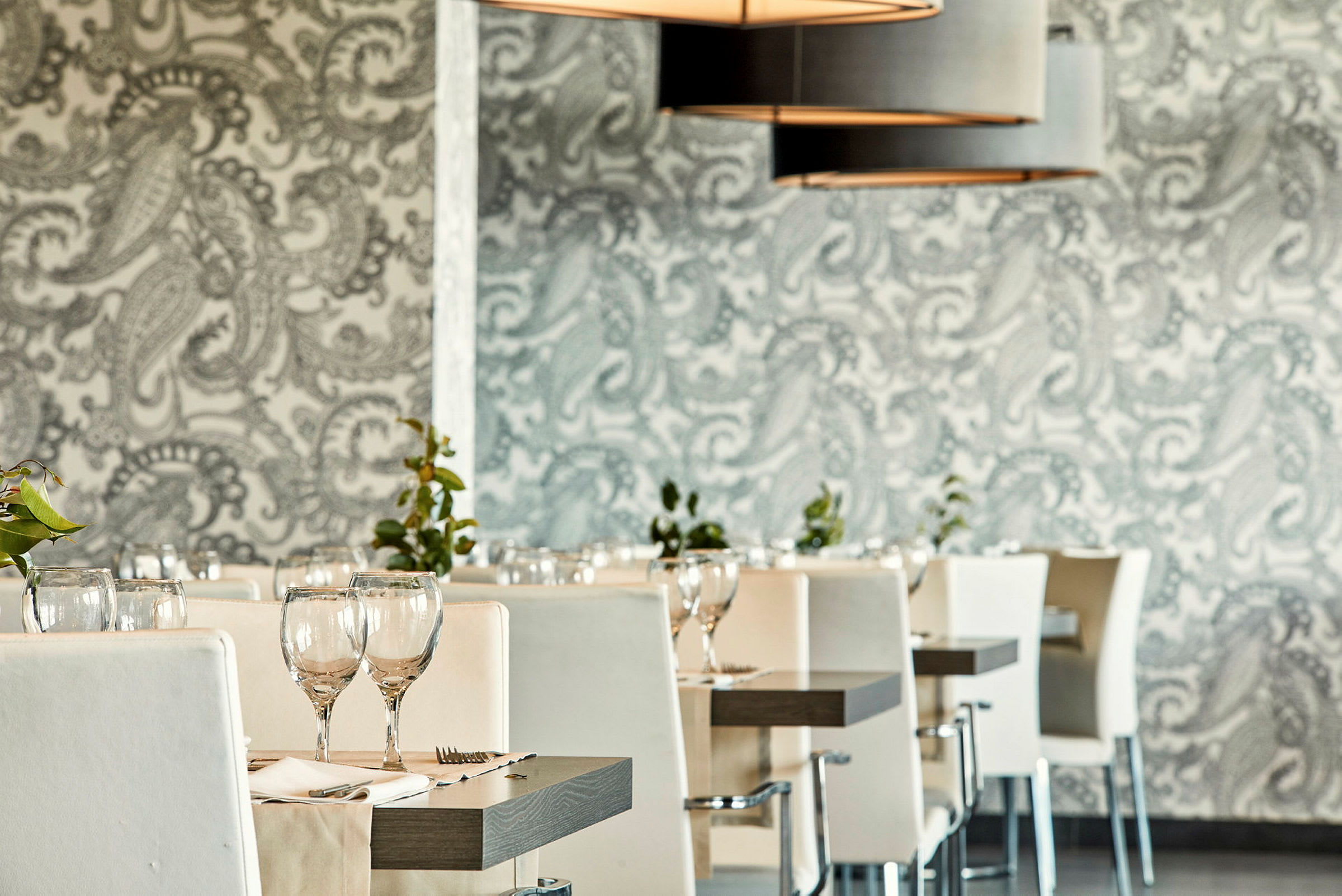 Restaurant med hvide stole og dækkede borde. (AI-genereret tekst)
