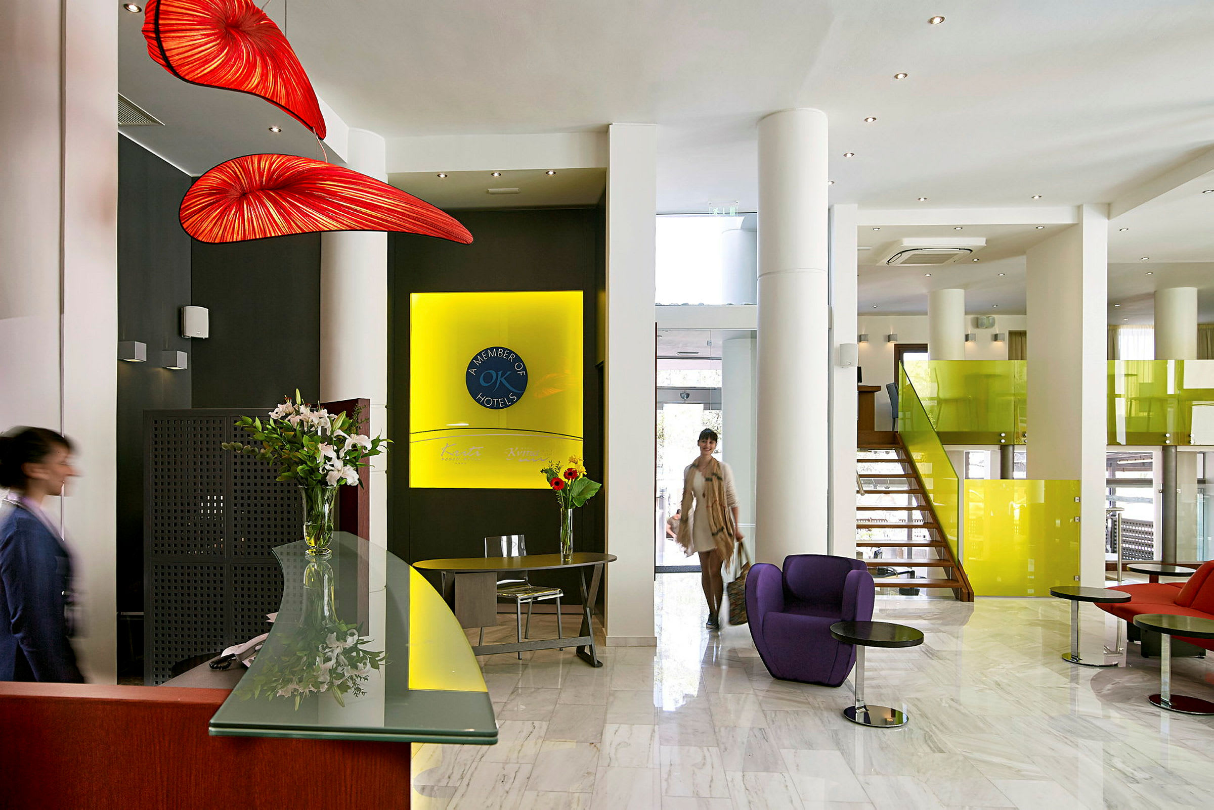 Hotellets lobby med reception og farverige møbler. (AI-genereret tekst)