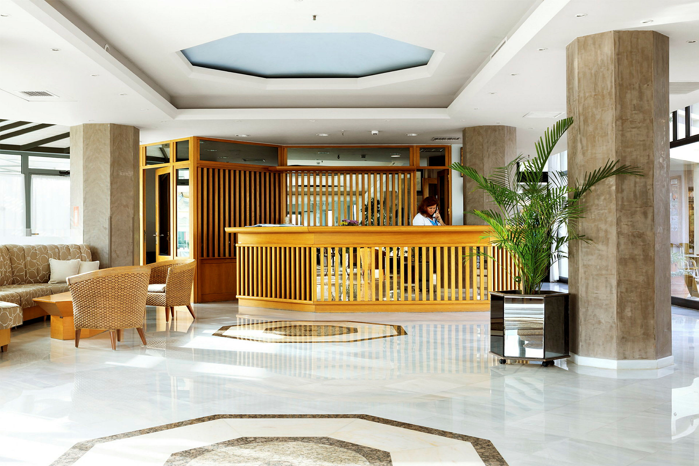 Reception i hotellobby med træindretning og planter. (AI-genereret tekst)