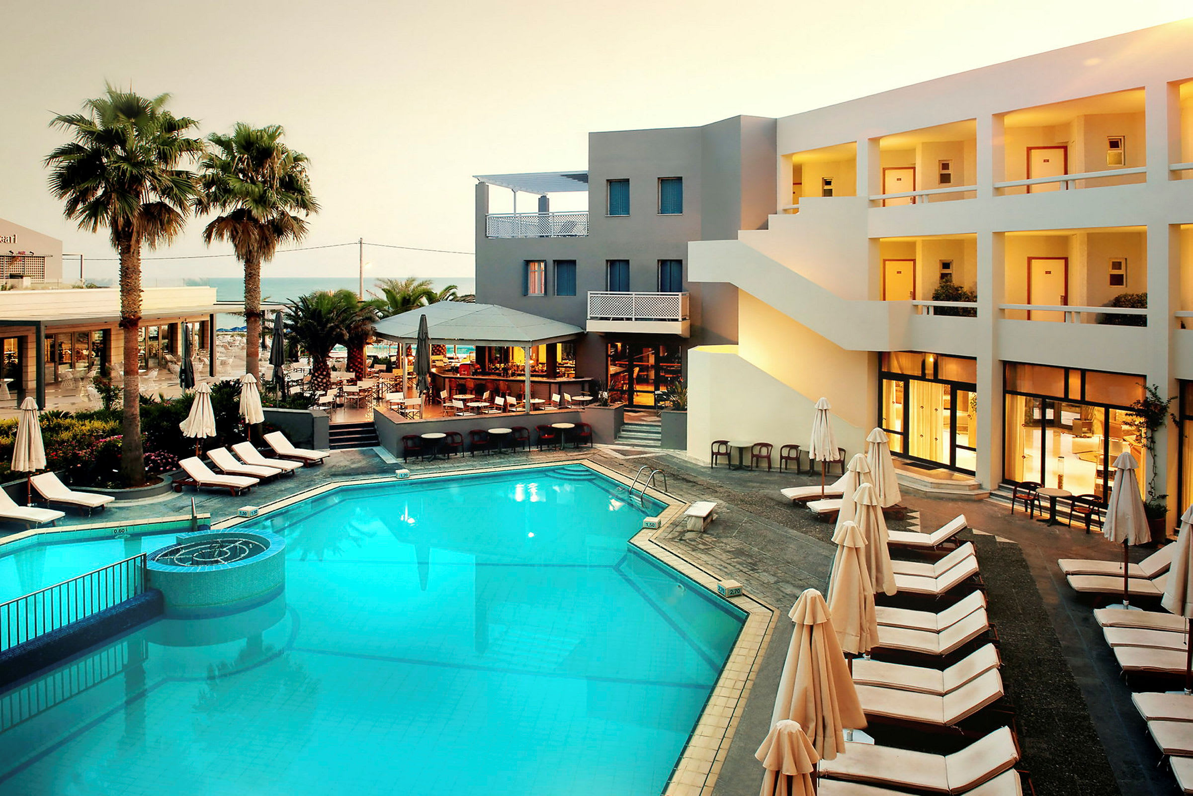 Hotel med pool, liggestole og restaurantområde. (AI-genereret tekst)