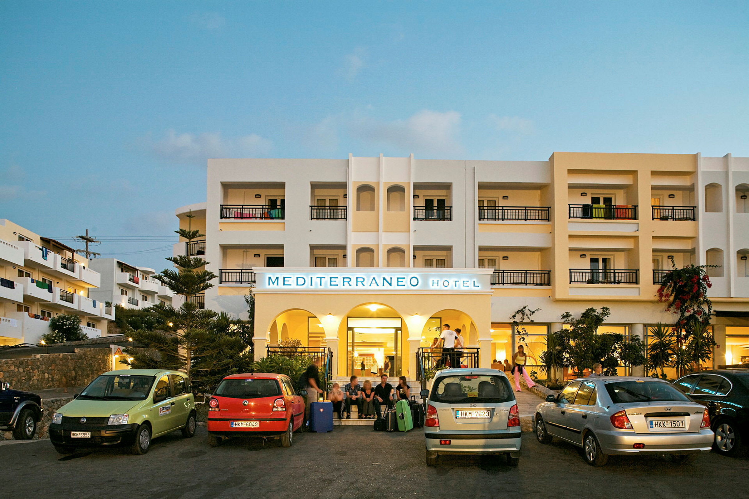 Billede af indgangen til Mediterraneo Hotel med parkerede biler foran. (AI-genereret tekst)