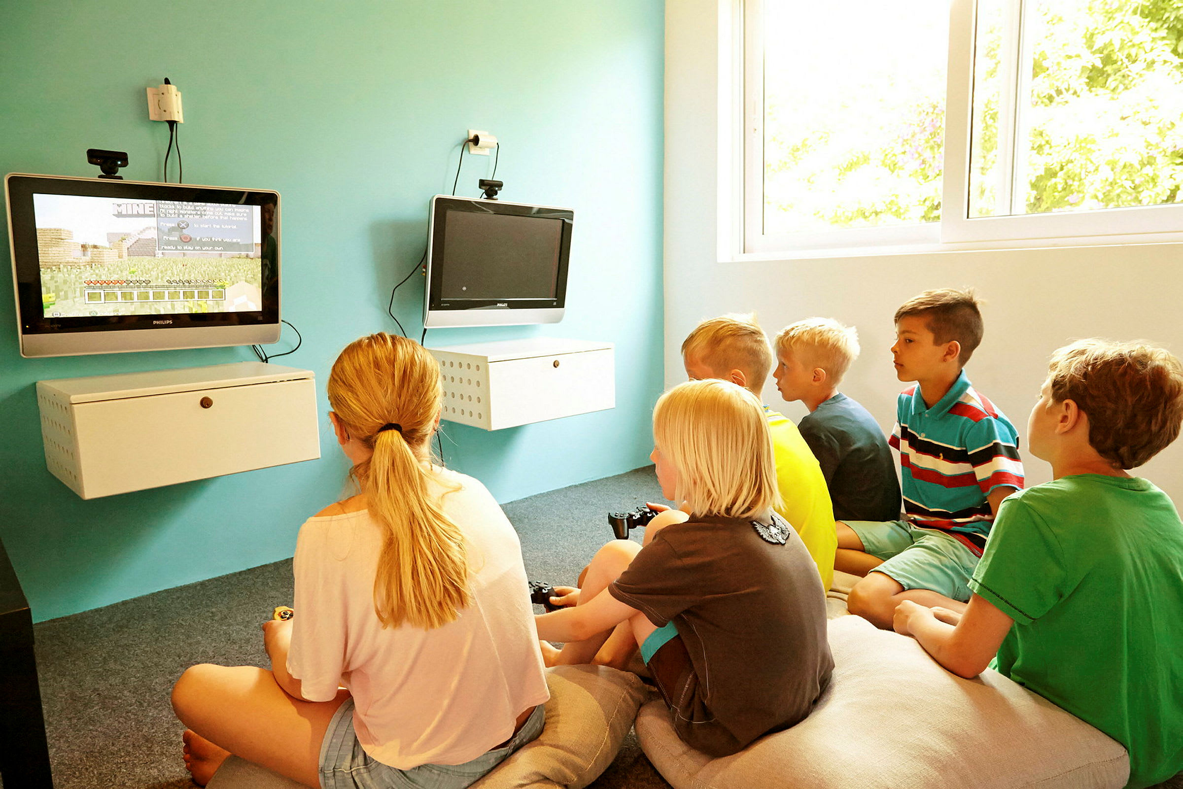 Børn der spiller tv-spil i et lyst rum. (AI-genereret tekst)