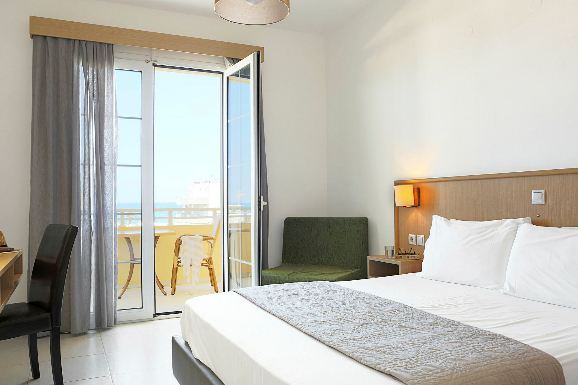 Et hotelværelse med en dobbeltseng og en balkon med udsigt. (AI-genereret tekst)
