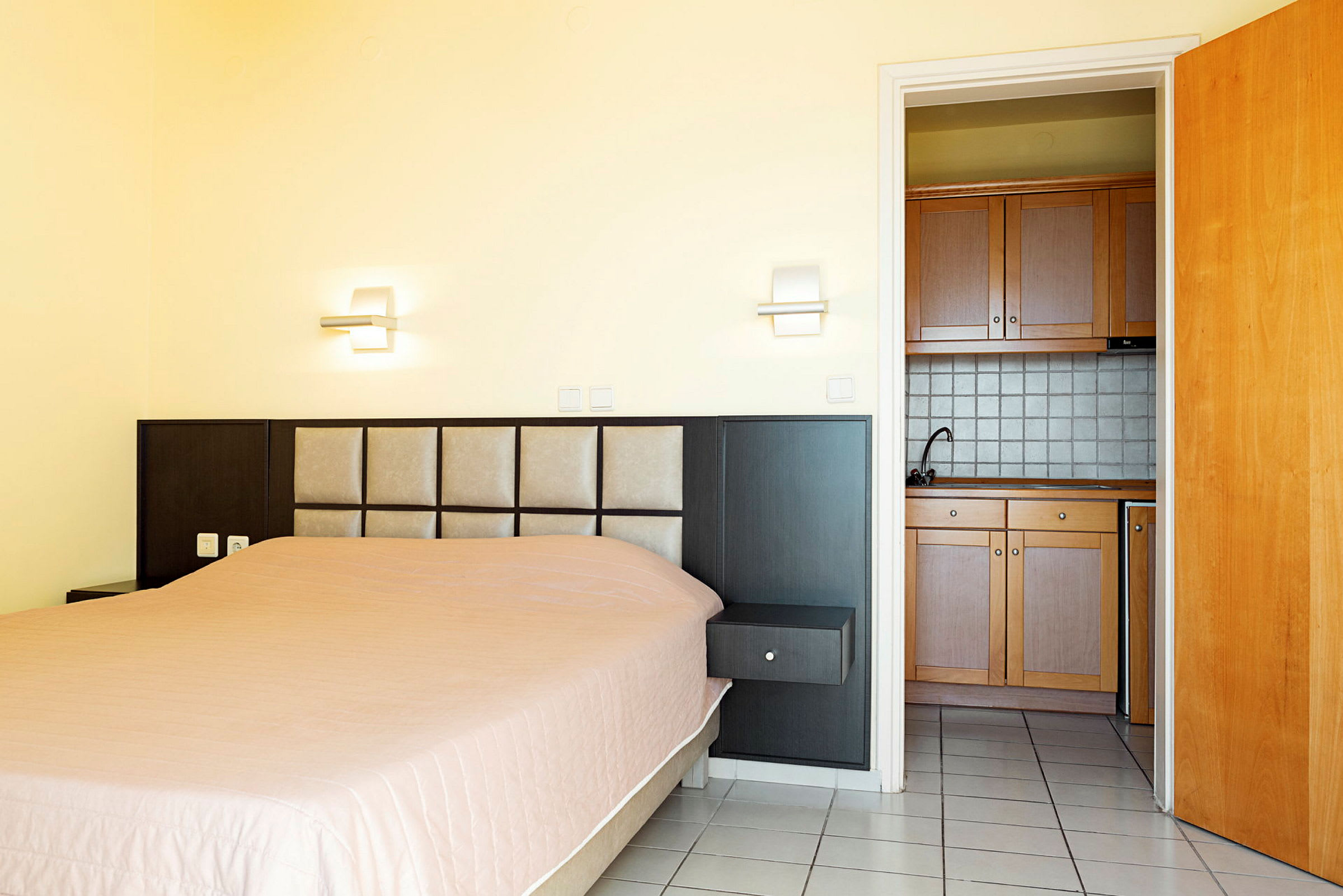 Hotelværelse med seng og minikøkken. (AI-genereret tekst)