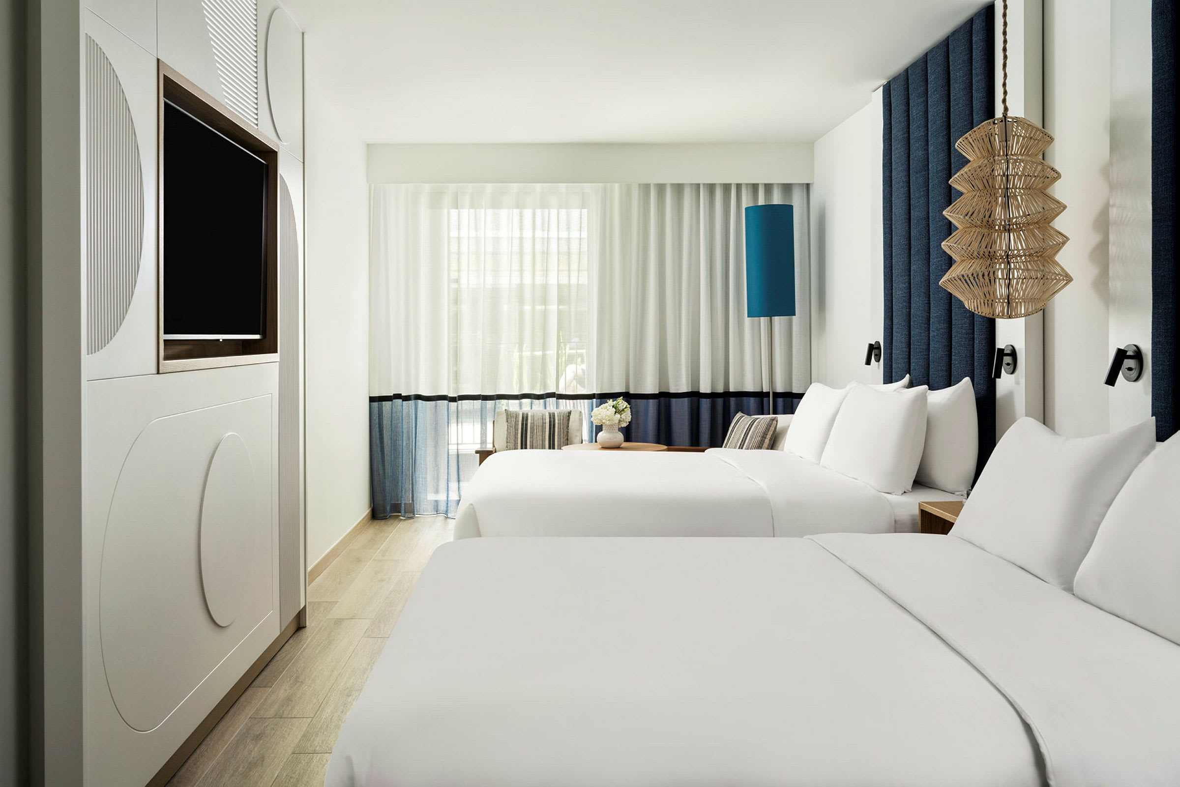 Hotelværelse med to dobbeltsenge og moderne indretning. (AI-genereret tekst)