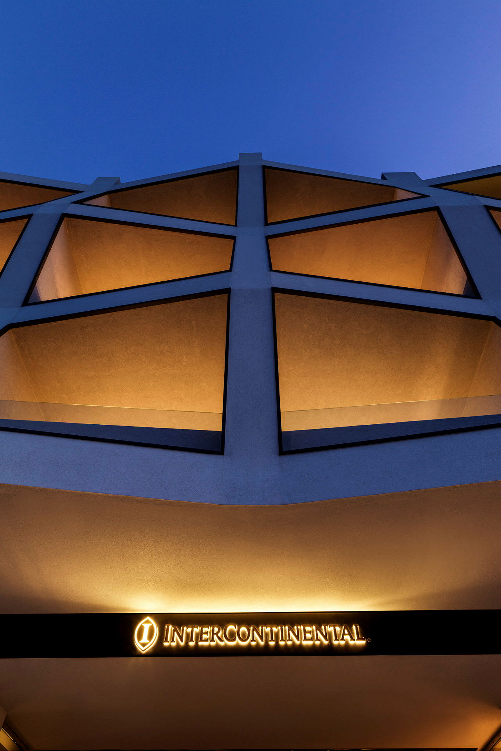 Facade af bygning med skiltet 'InterContinental', blå himmel i baggrunden. (AI-genereret tekst)