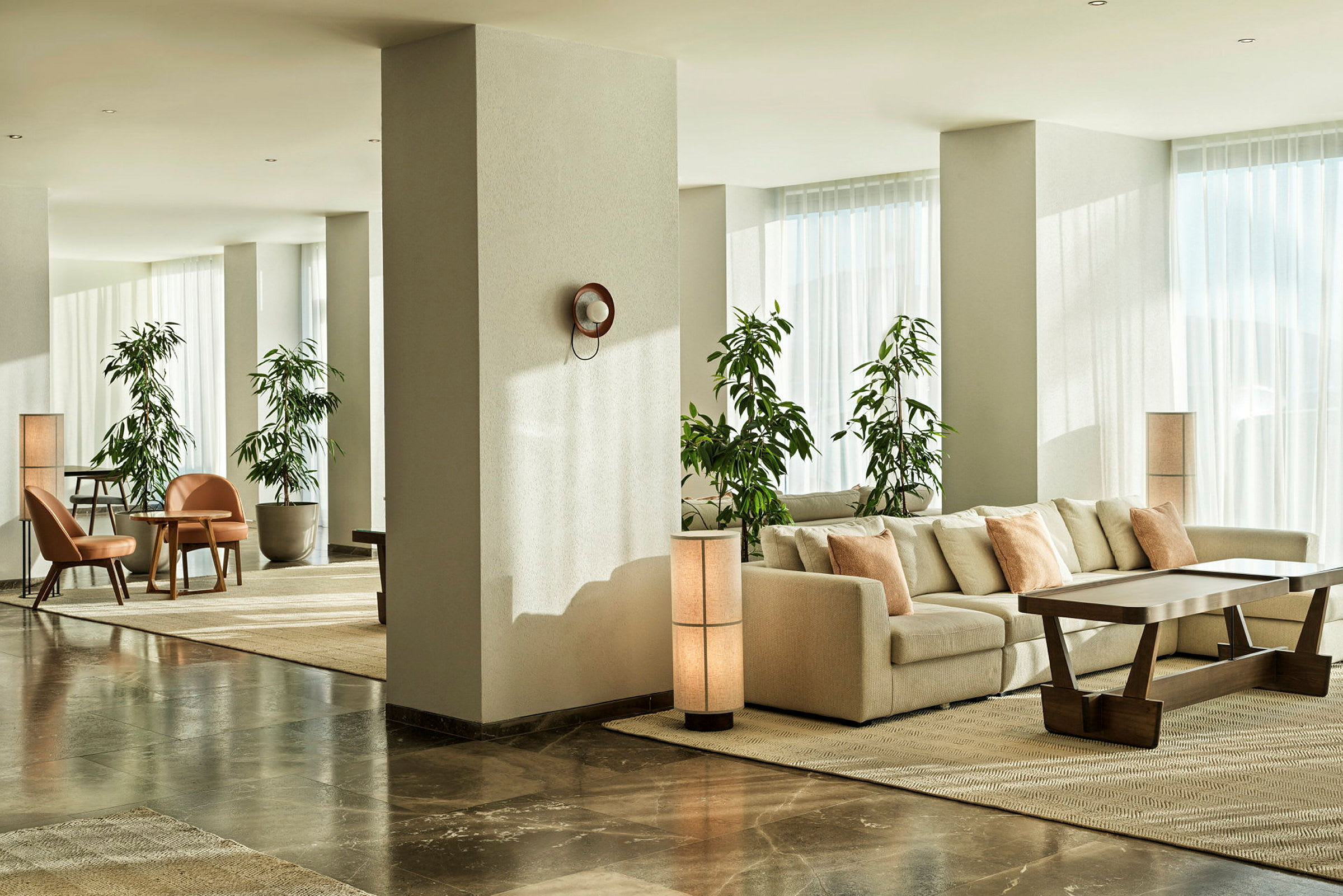 Moderne hotelværelse med sofagruppe og grønne planter. (AI-genereret tekst)