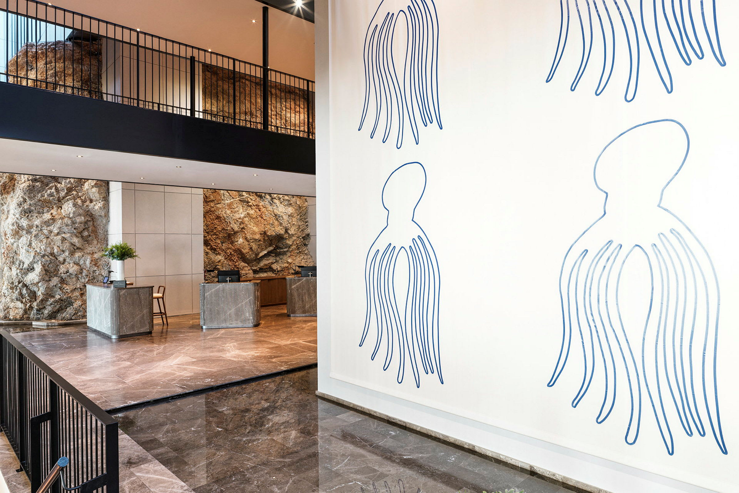 Lobby med reception, kunst på væggen og natursten som dekoration. (AI-genereret tekst)