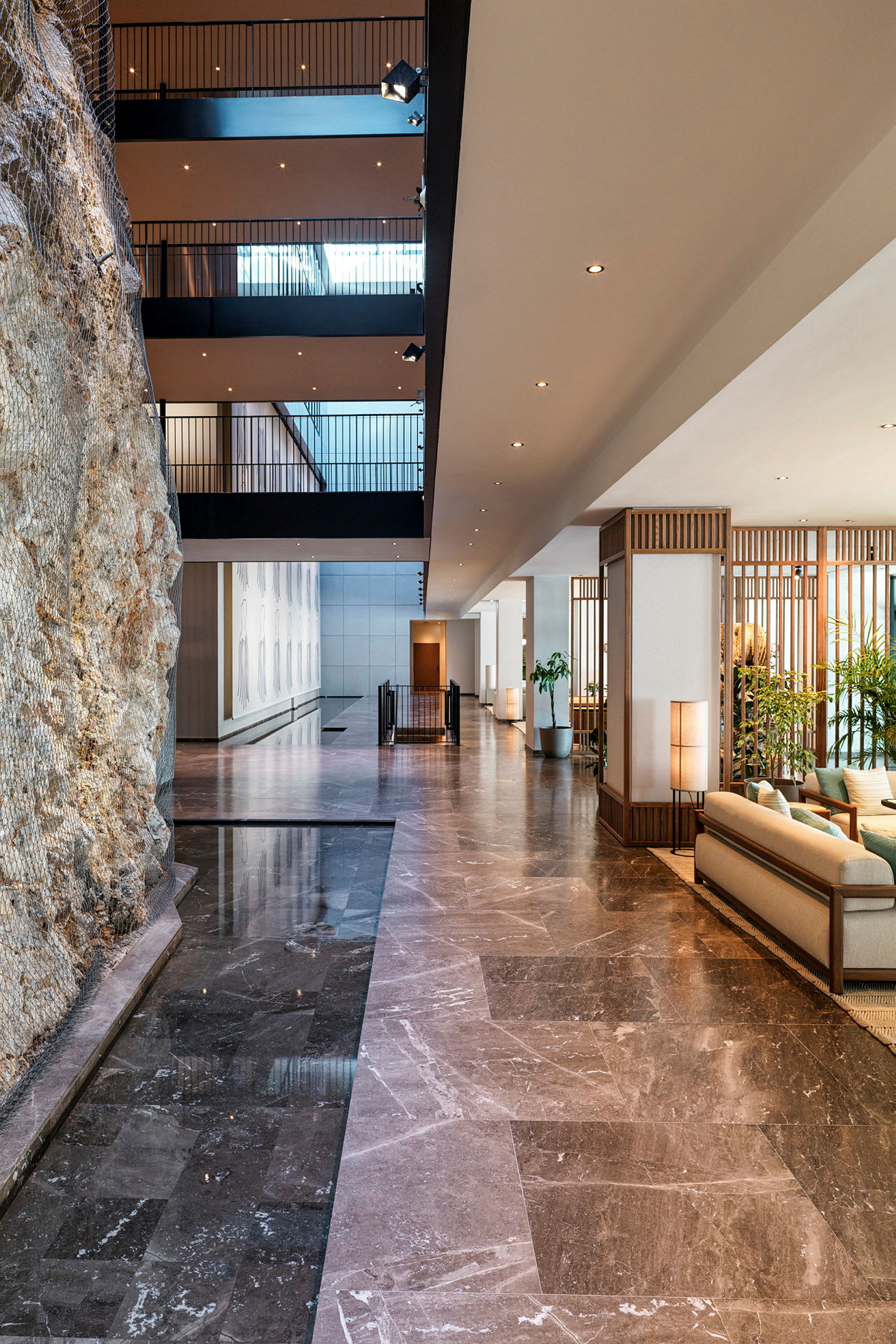 Interiør af en elegant hotellobby med marmor, siddepladser og dekorative elementer. (AI-genereret tekst)