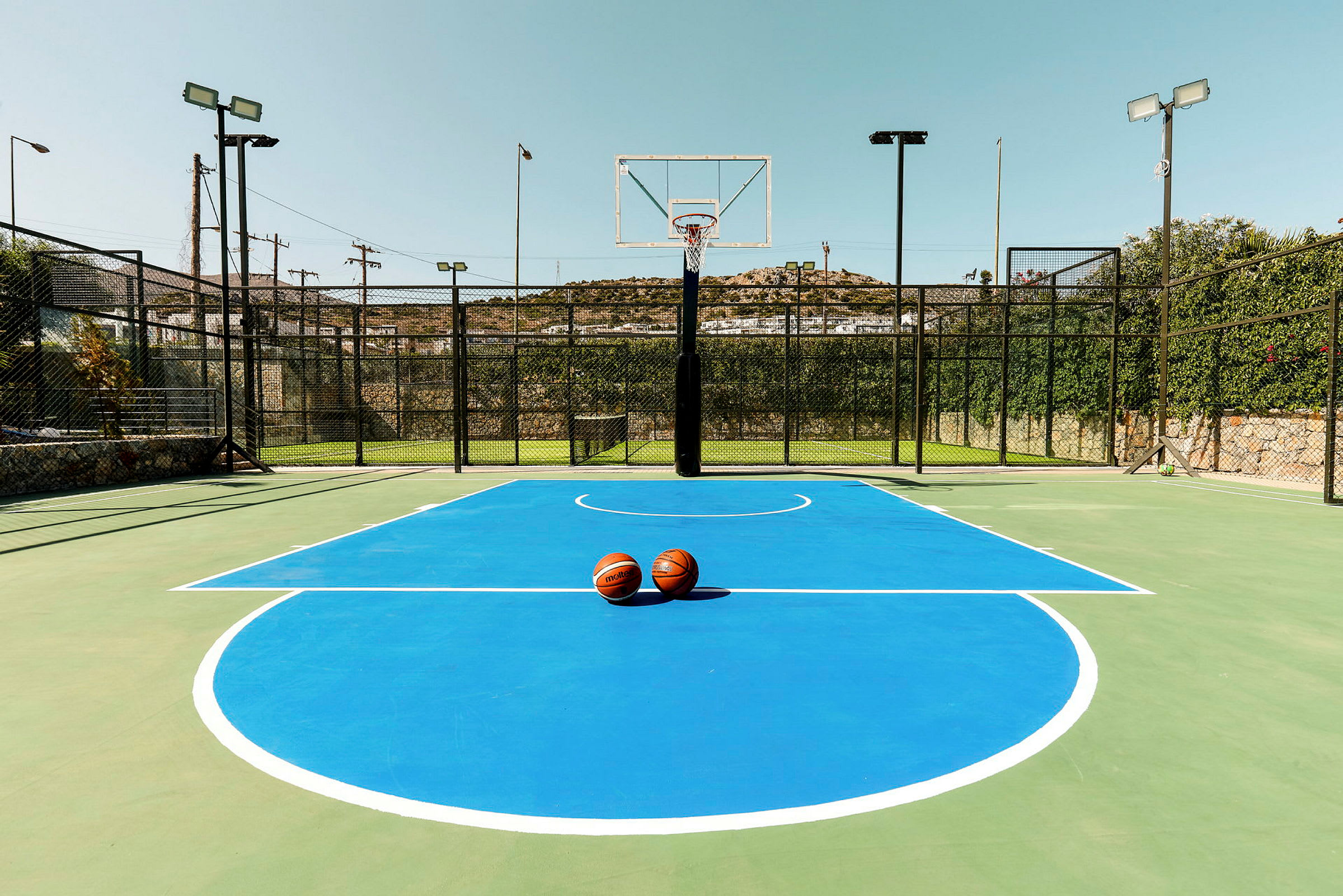 En basketballbane med blå markeringer og to basketballer placeret i midten. (AI-genereret tekst)