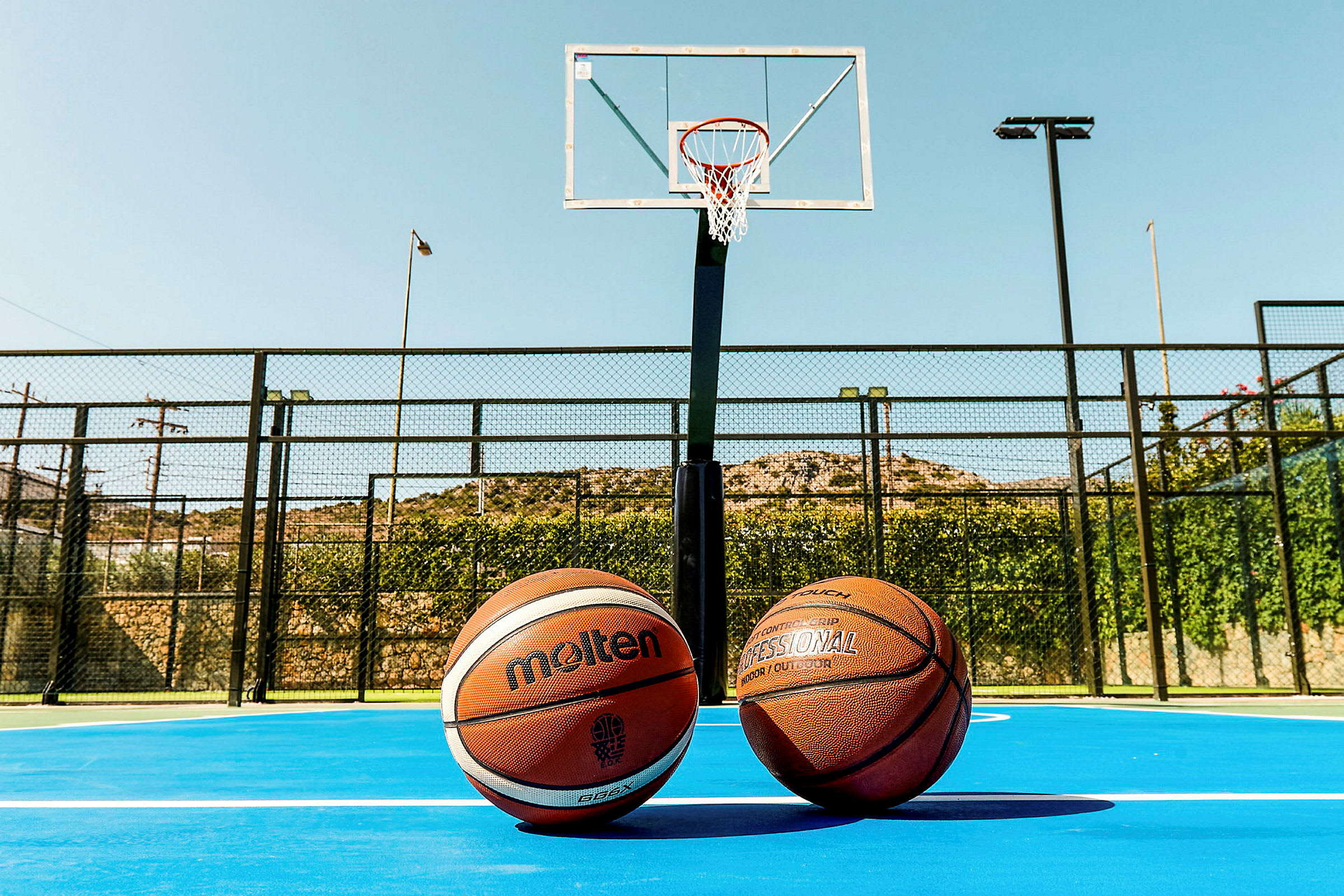 To basketballer på en basketballbane foran en basketballkurv. (AI-genereret tekst)