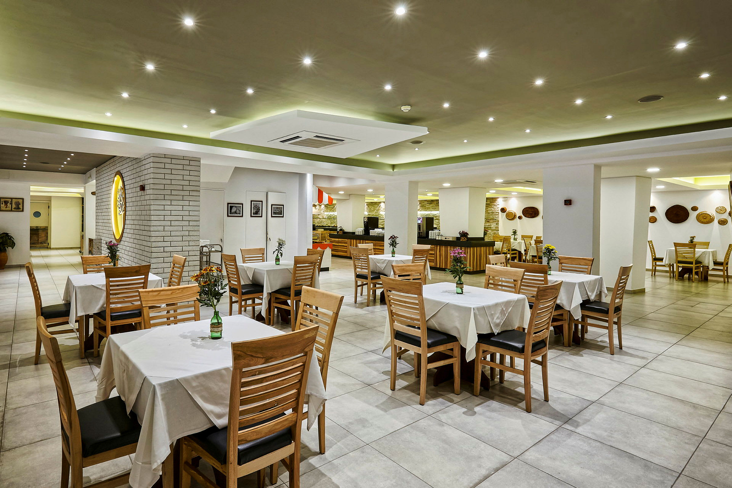 Restaurantmiljø med borde og stole, dekoreret med vaser og blomster. (AI-genereret tekst)