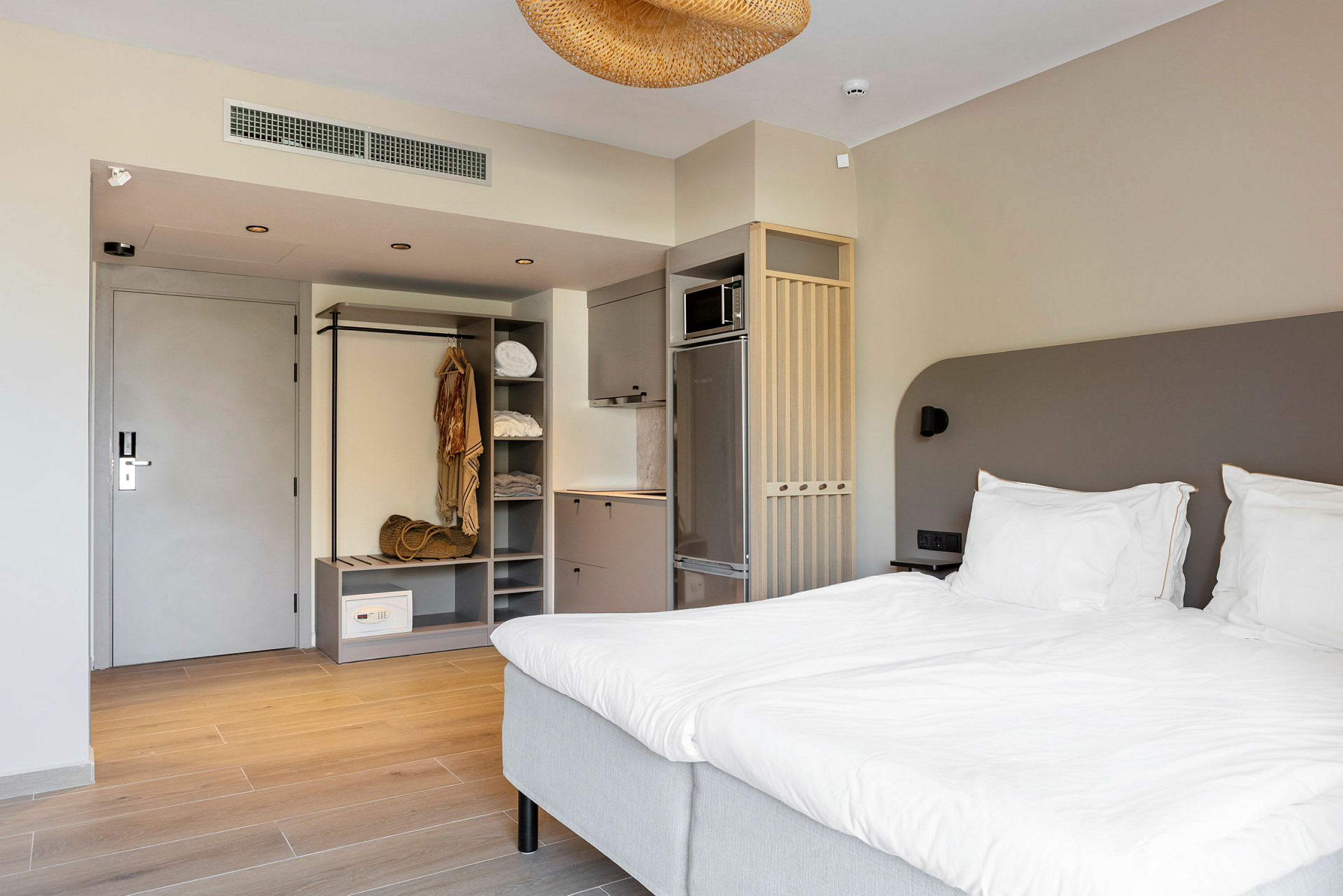 Et hotelværelse med en dobbeltseng, garderobe og køkkenudstyr. (AI-genereret tekst)