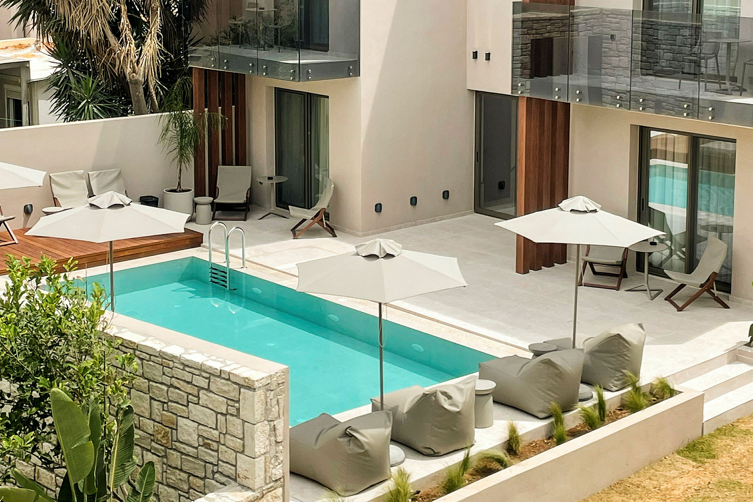 Moderne hotelpool omgivet af liggestole og parasoller. (AI-genereret tekst)
