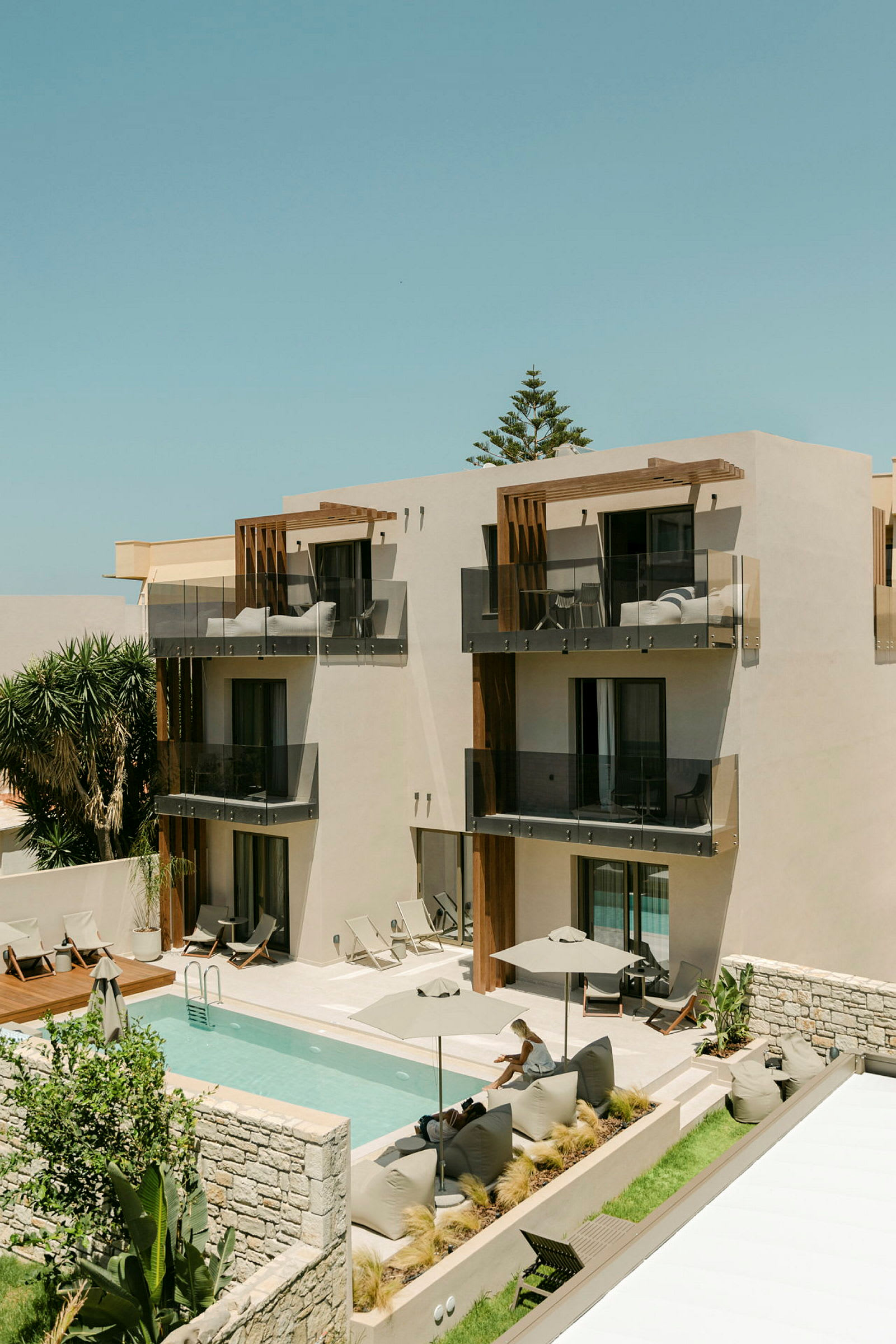 Moderne hotel med pool og liggestole. (AI-genereret tekst)