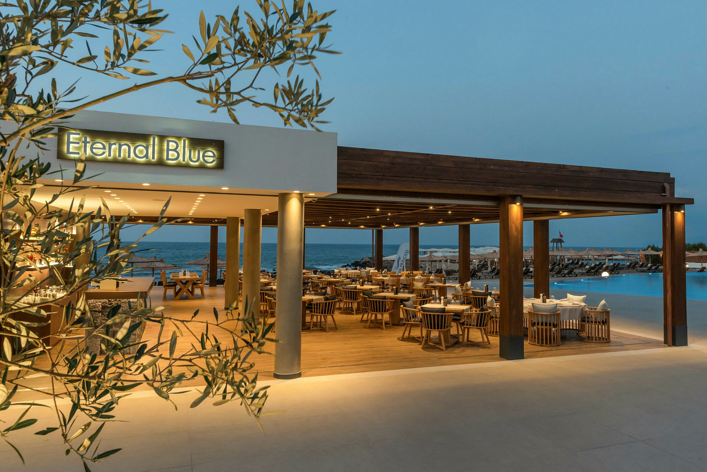 En restaurant ved navn 'Eternal Blue', med udsigt over en pool og havet i baggrunden. (AI-genereret tekst)