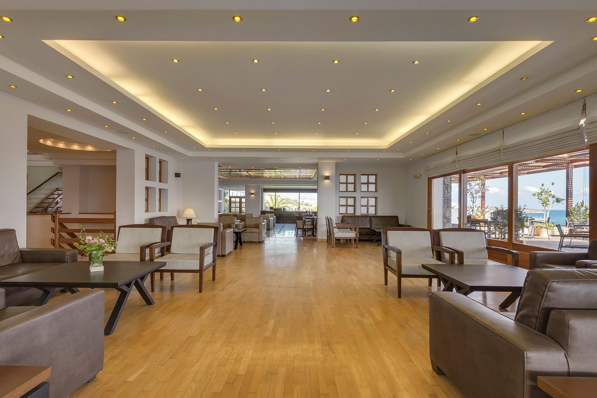 Hotellobby med moderne møbler og vinduer mod udsigt. (AI-genereret tekst)