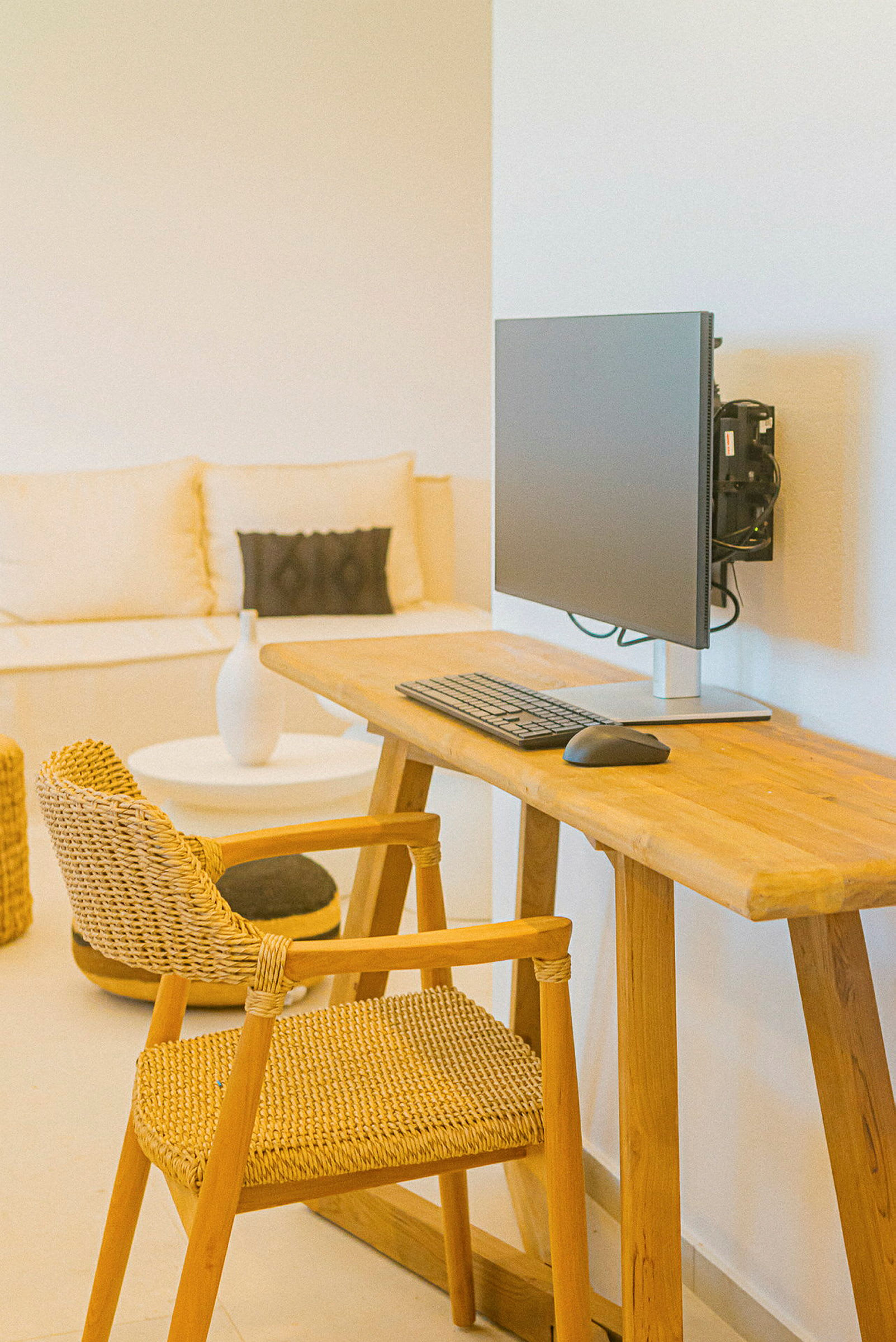 En arbejdsplads med et træskrivebord, stol og computerskærm. (AI-genereret tekst)