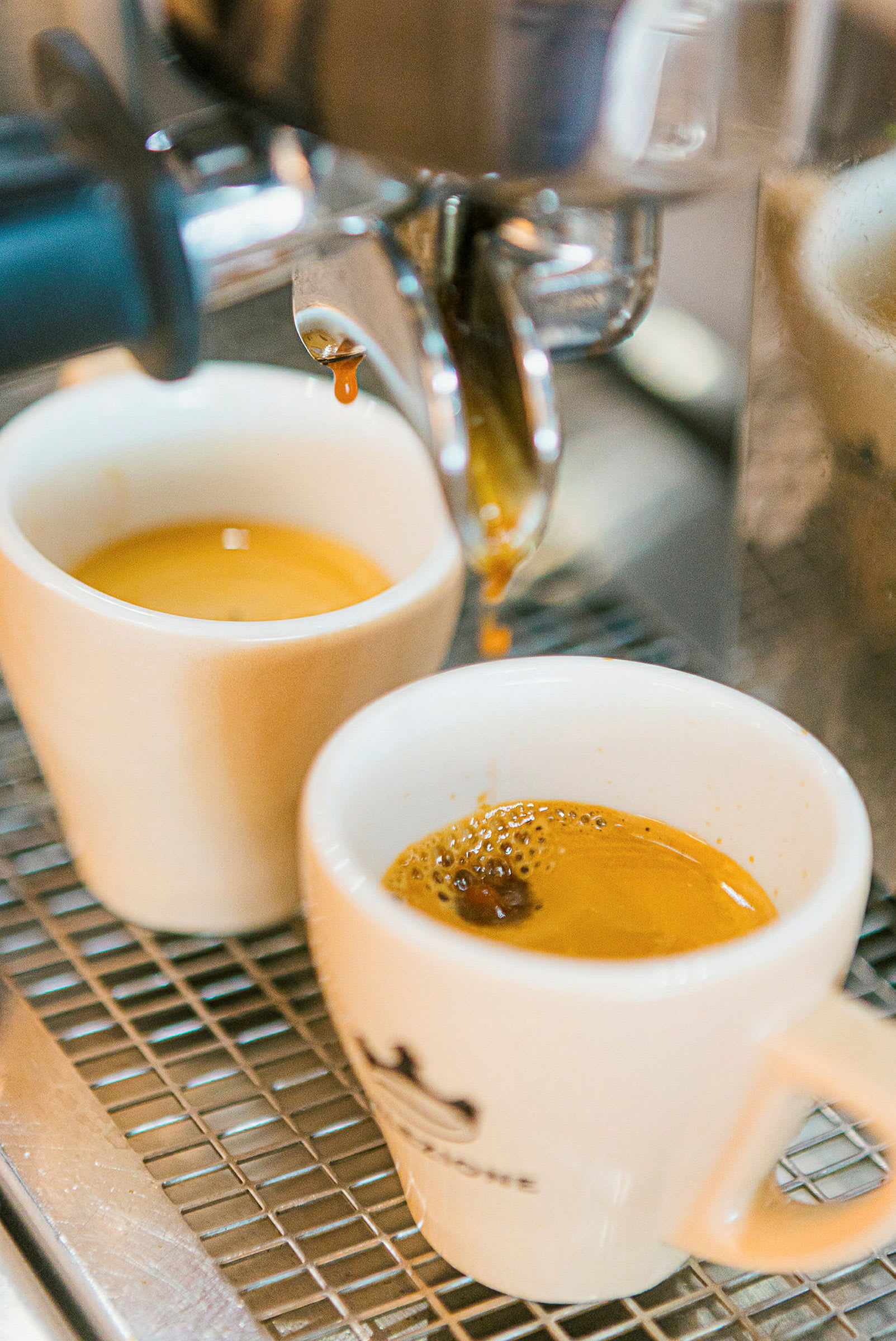 Espressobrygning med to hvide kopper under maskinen. (AI-genereret tekst)