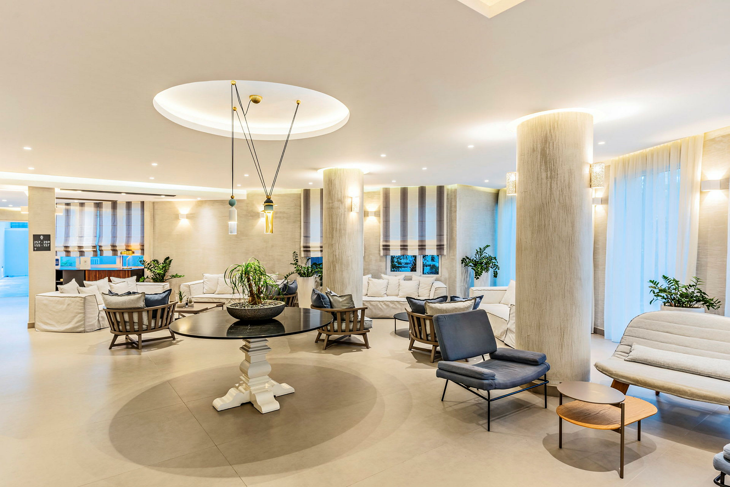 Lyst og stilfuldt indrettet hotellobbyområde med siddegrupper og dekorative elementer. (AI-genereret tekst)