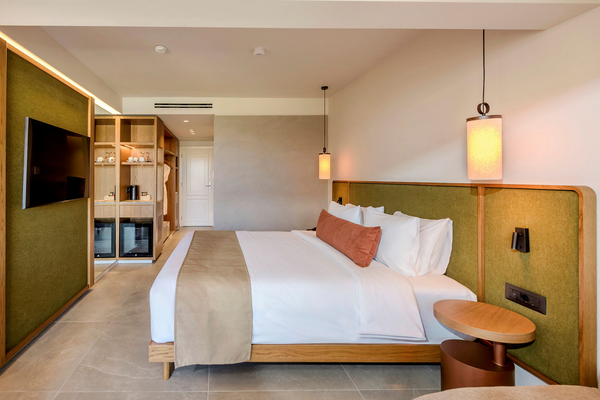 Billede af et moderne hotelværelse med en dobbeltseng, møbler i træ og grønne detaljer. (AI-genereret tekst)