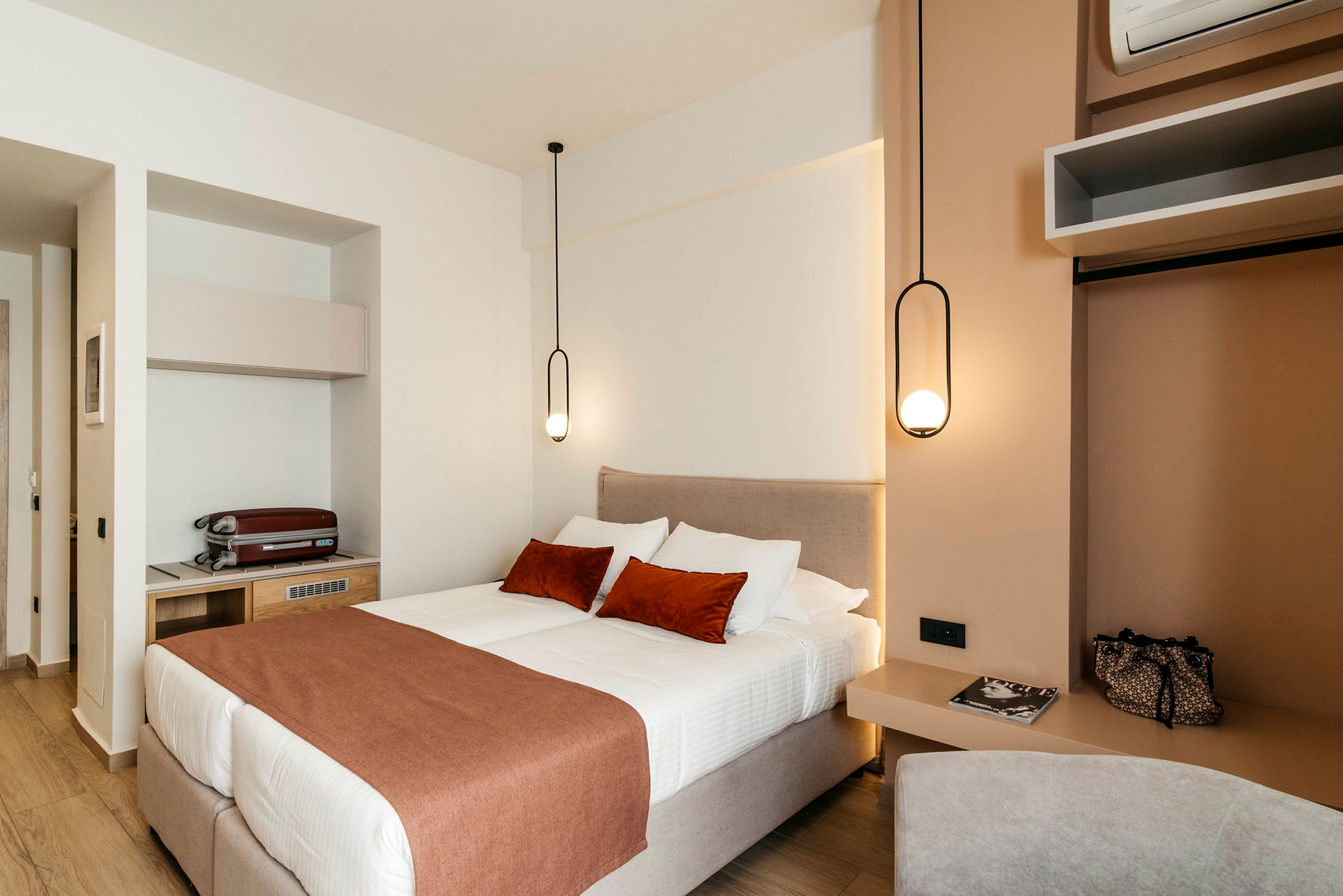 Et moderne hotelværelse med en dobbeltseng og elegant hængende lamper. (AI-genereret tekst)