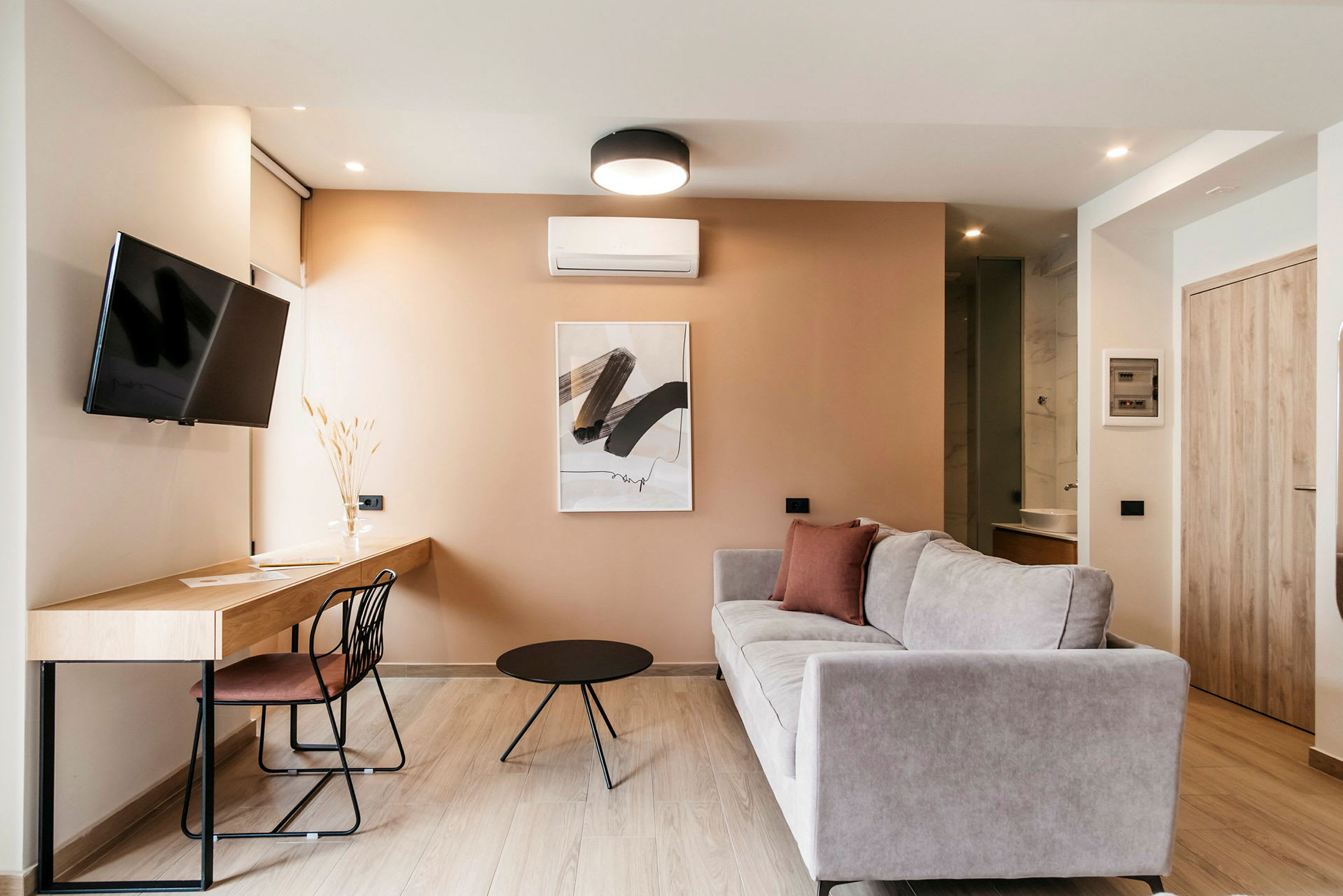 En moderne indrettet stue med sofa, arbejdsbord og TV. (AI-genereret tekst)