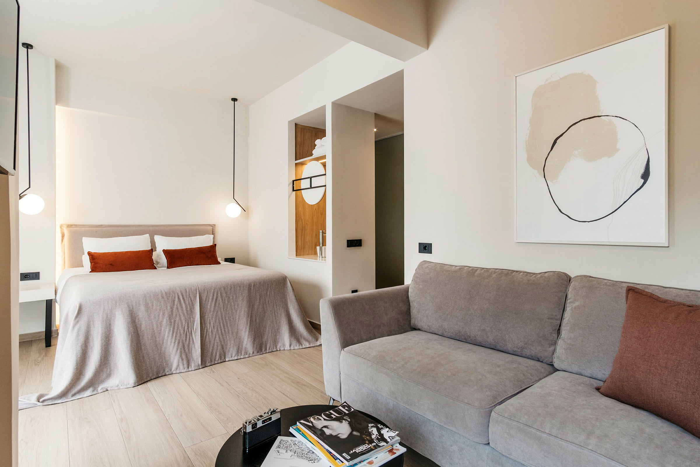 Et moderne hotelværelse med en stor seng, sofa og minimalistisk indretning. (AI-genereret tekst)