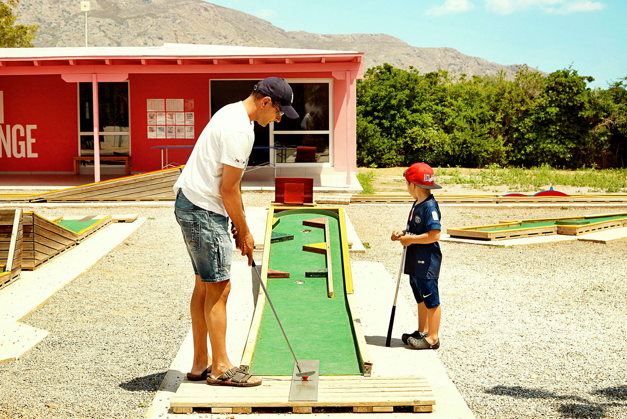 To personer spiller minigolf på en bane udendørs. (AI-genereret tekst)