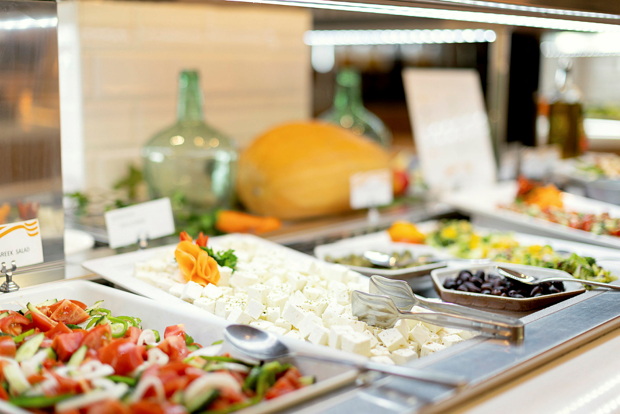 Billede af en buffet med salat, fetaost, oliven og grøntsager. (AI-genereret tekst)