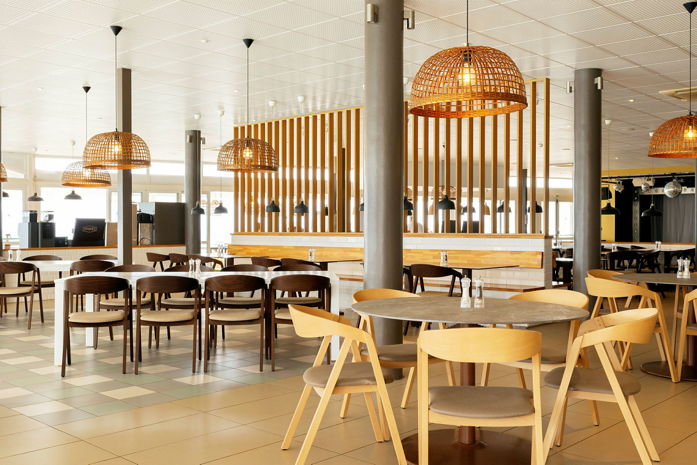 Billede af en moderne restaurant med træmøbler og rottinglamper. (AI-genereret tekst)