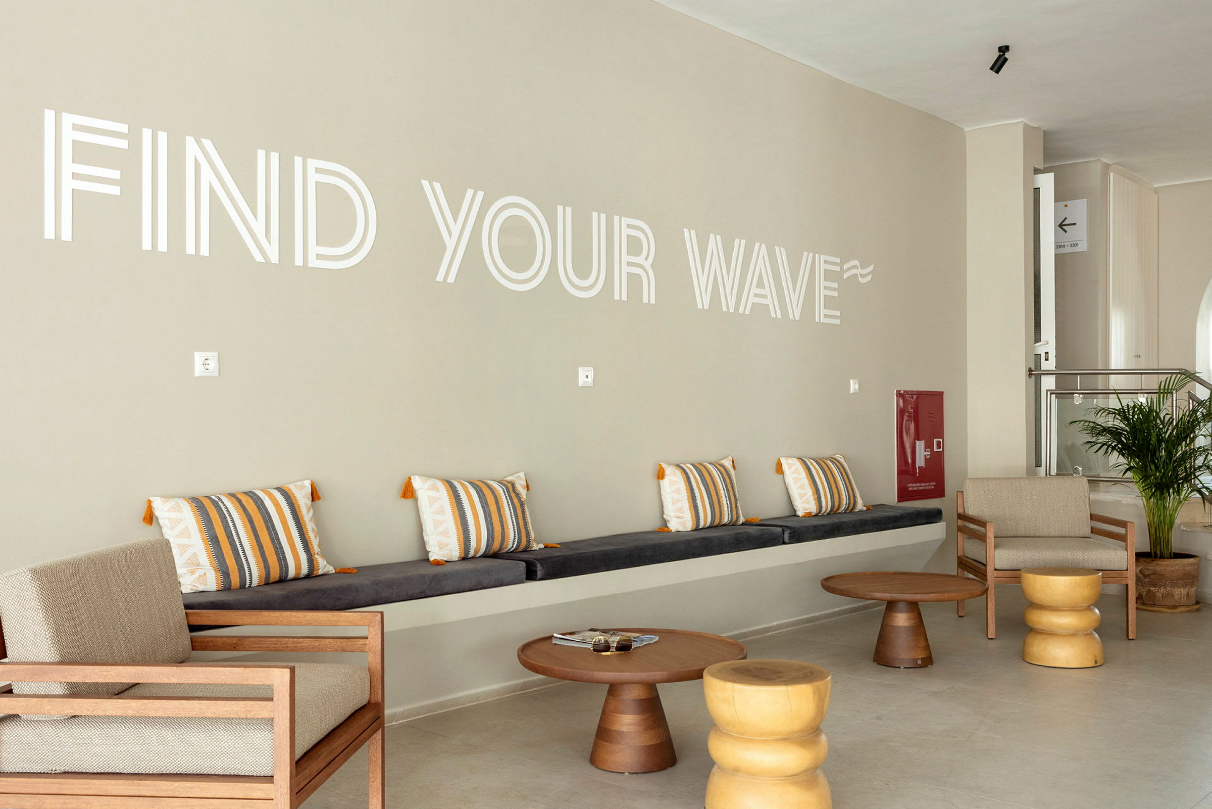 En lounge med siddepladser og teksten 'Find Your Wave' på væggen. (AI-genereret tekst)