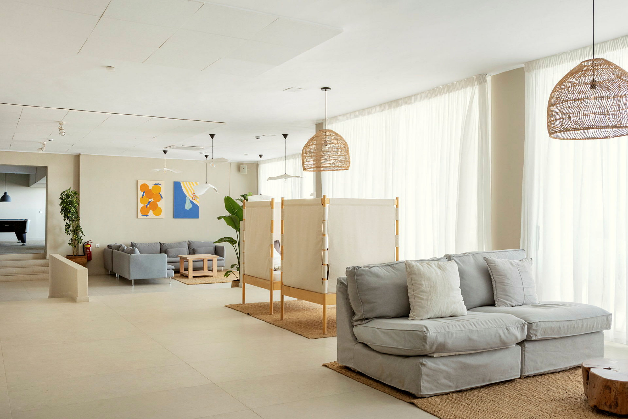 En moderne og lys stue med sofaer, borde og vægdekorationer. (AI-genereret tekst)