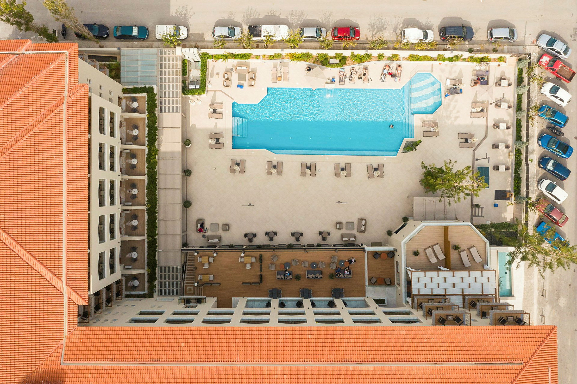 Luftfoto af hotel i destination med stor swimmingpool og liggestole. (AI-genereret tekst)