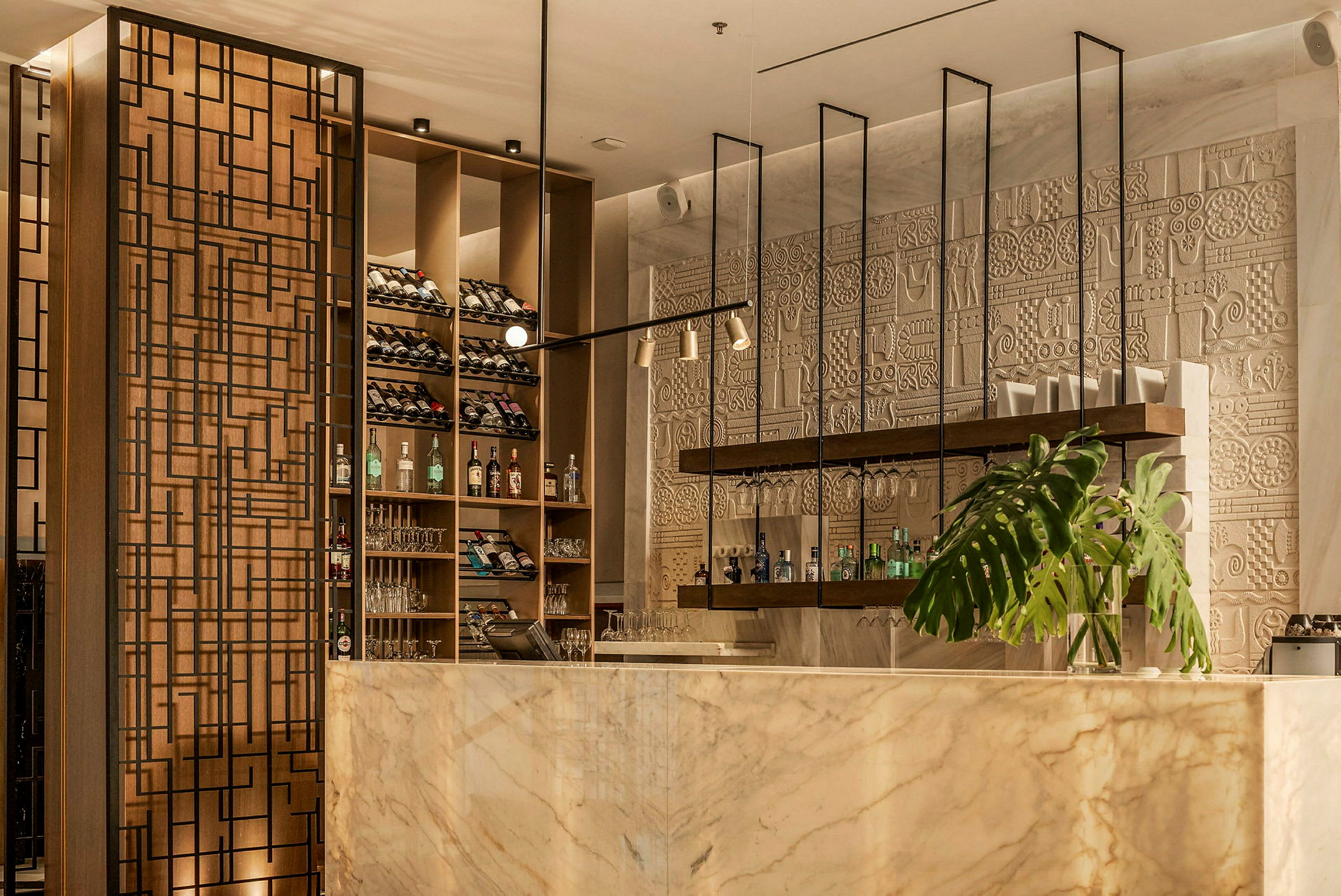 Elegant bar med marmordisk, vinhylder, dekorativ væg og plante. (AI-genereret tekst)