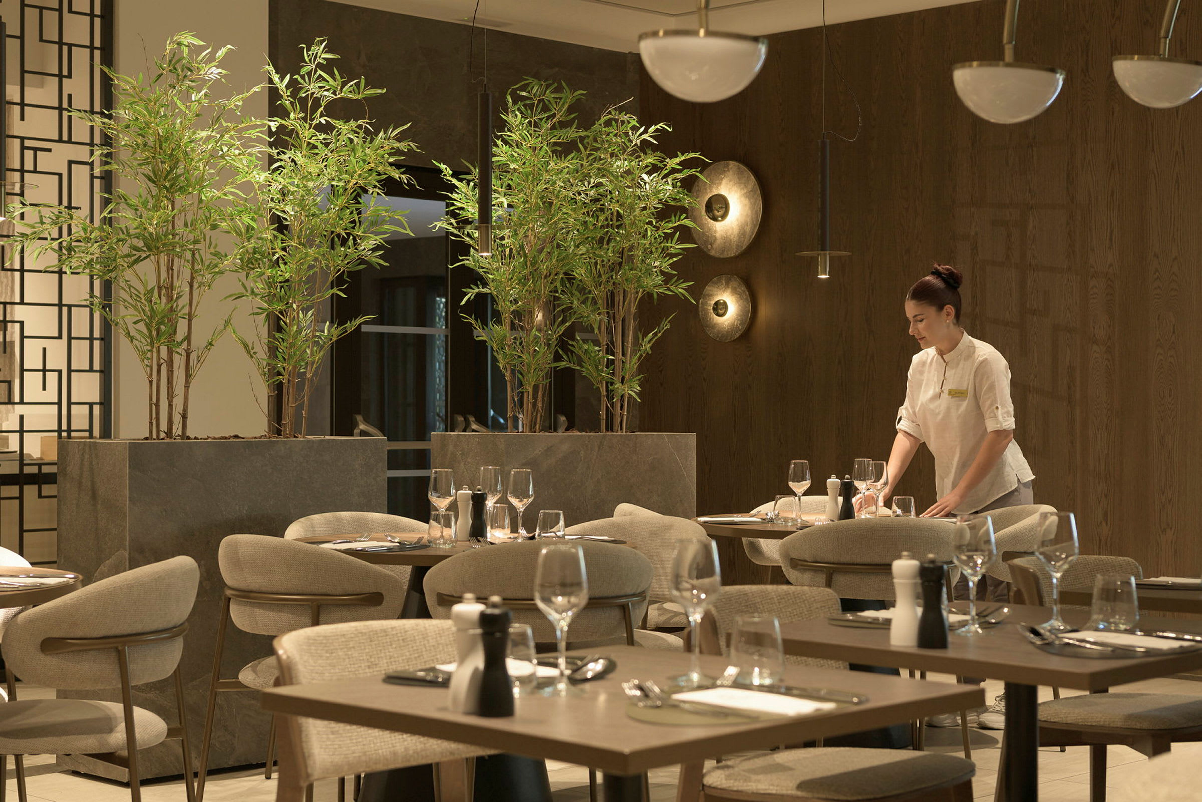 En elegant restaurant med moderne møbler og levende grønne planter. (AI-genereret tekst)