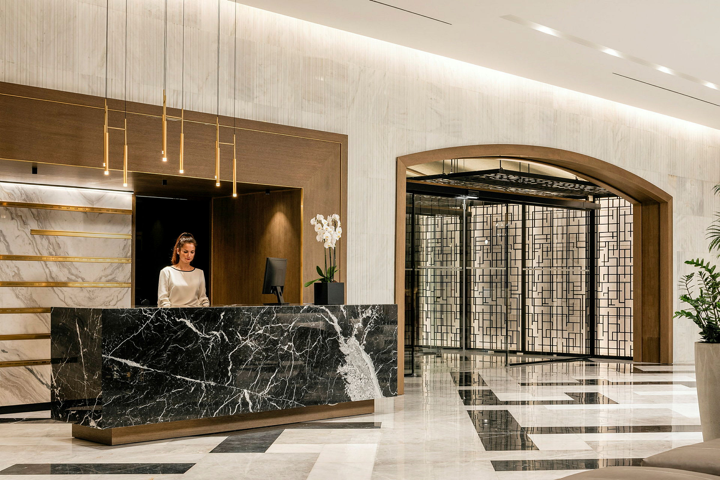 Hotellets reception med marmordisk og elegant indretning. (AI-genereret tekst)