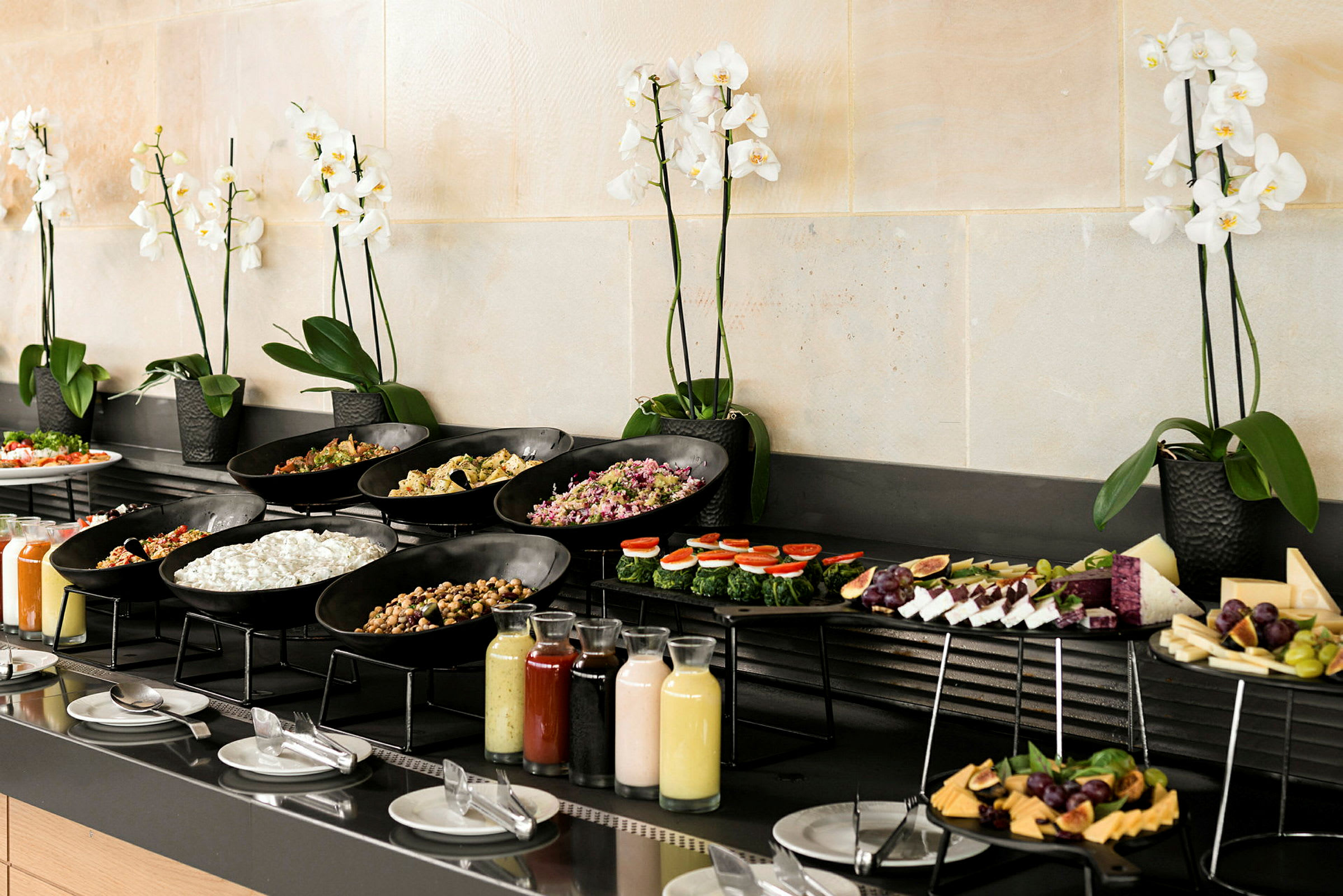En buffet med forskellige retter og drikkevarer, dekoreret med hvide orkidéer. (AI-genereret tekst)