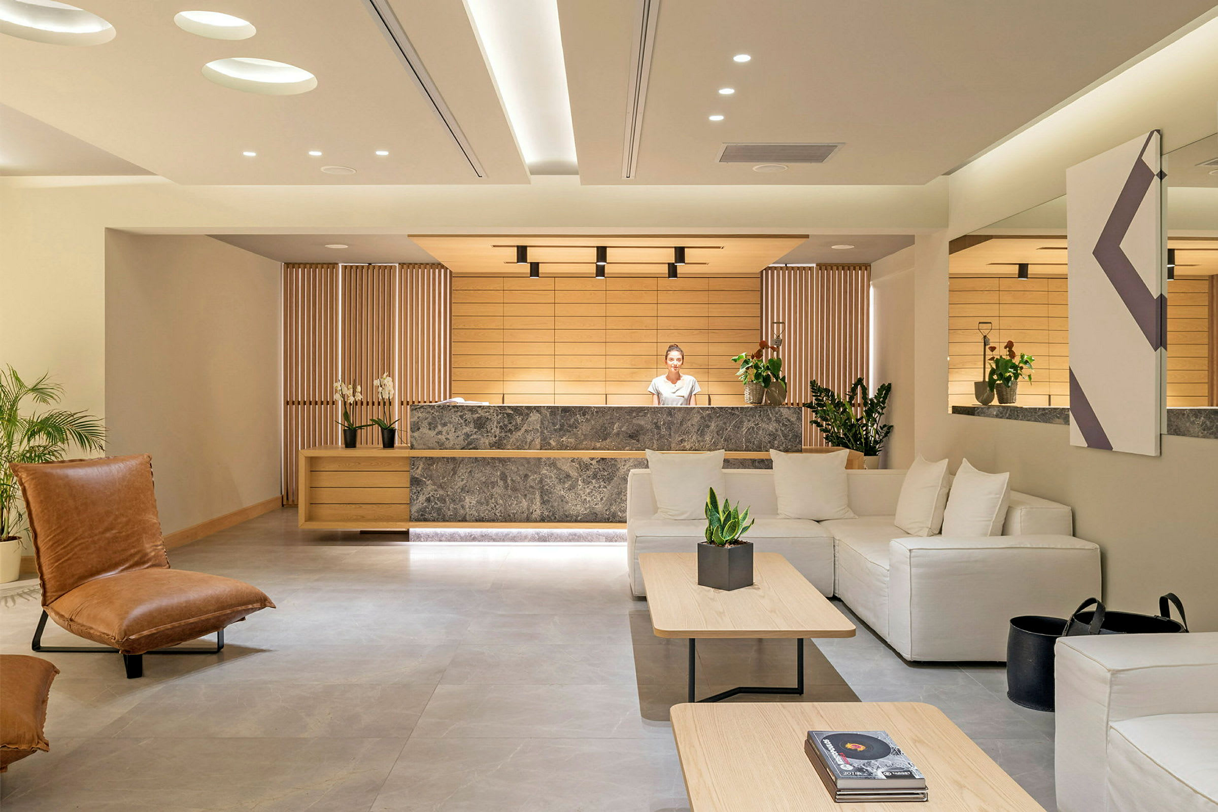 Et moderne hotellobbyområde med reception og siddeområde. (AI-genereret tekst)