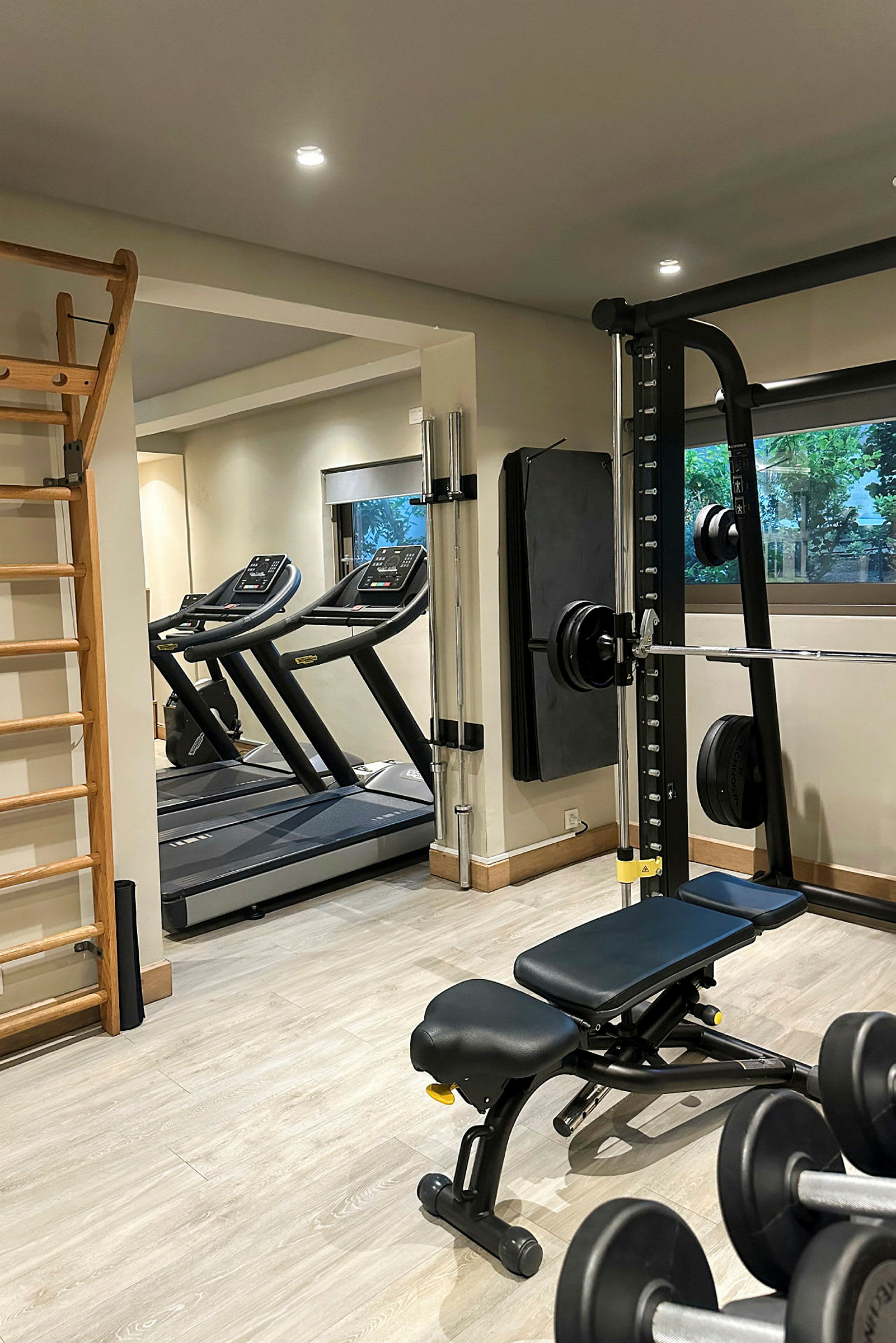 Et fitnesscenter med træningsudstyr, herunder løbebånd, vægte og en træningsbænk. (AI-genereret tekst)