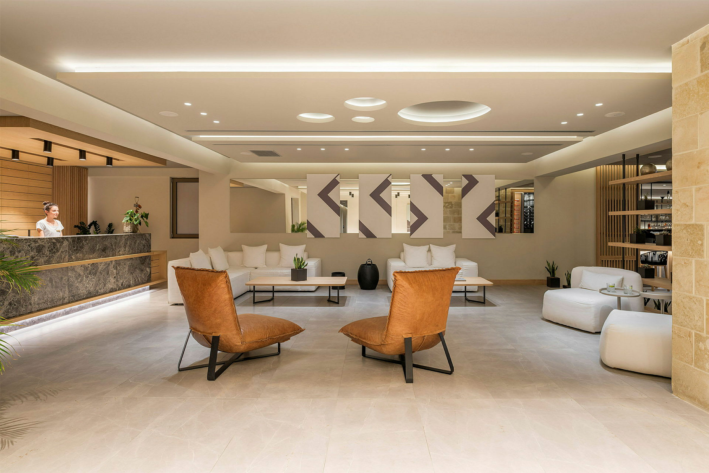 En moderne hotellobby med sofagruppe og marmormodtagelsesdisk. (AI-genereret tekst)