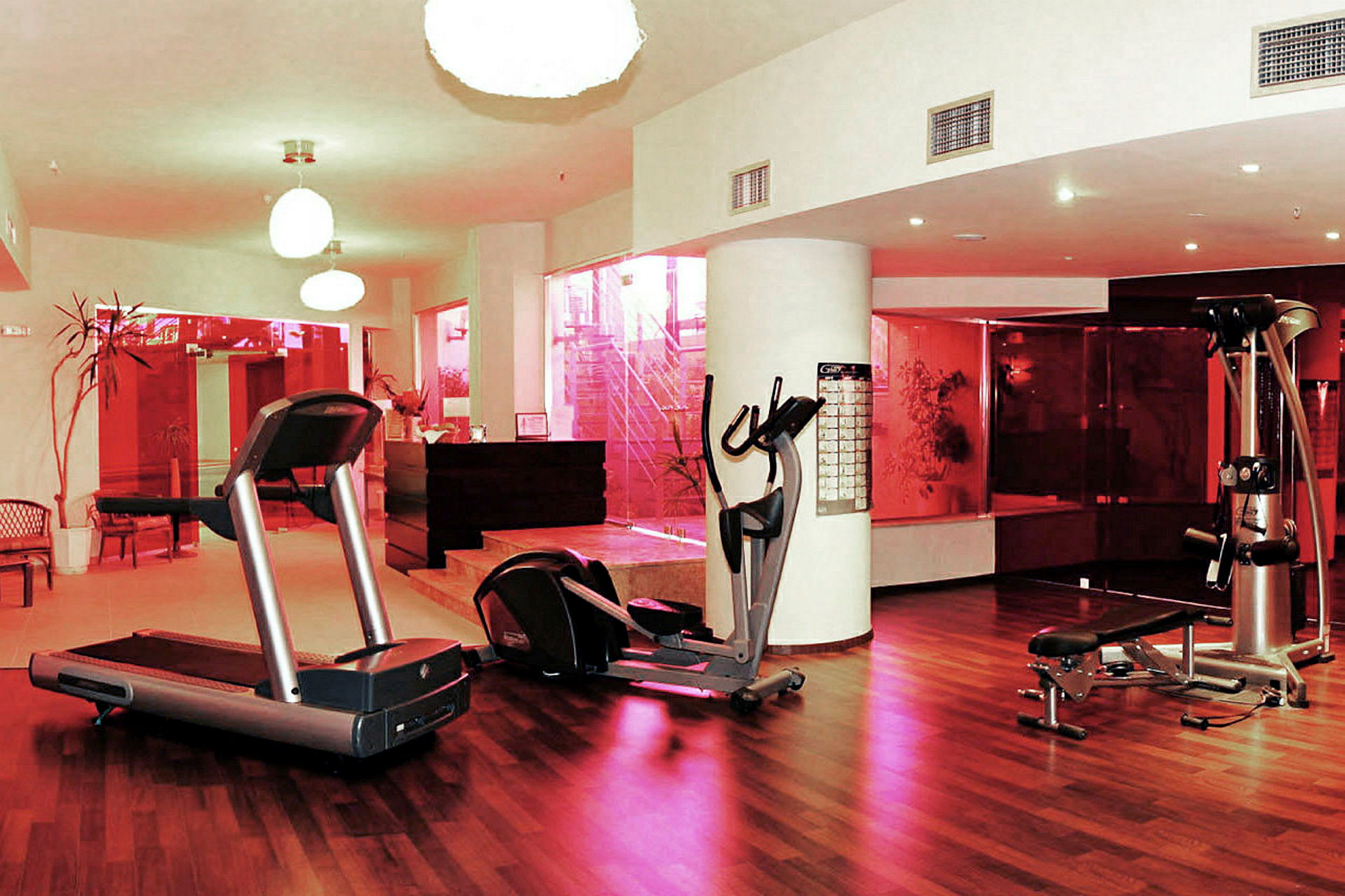 Billede af et fitnesscenter med træningsudstyr og trægulv. (AI-genereret tekst)