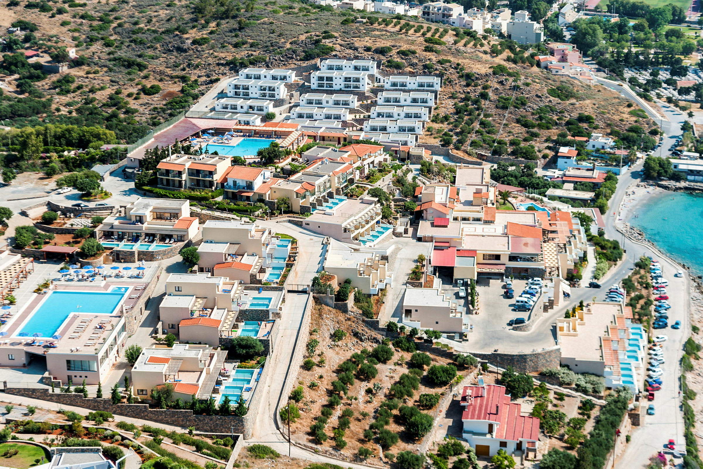 Luftfoto af hotelområde med swimmingpools og strand. (AI-genereret tekst)