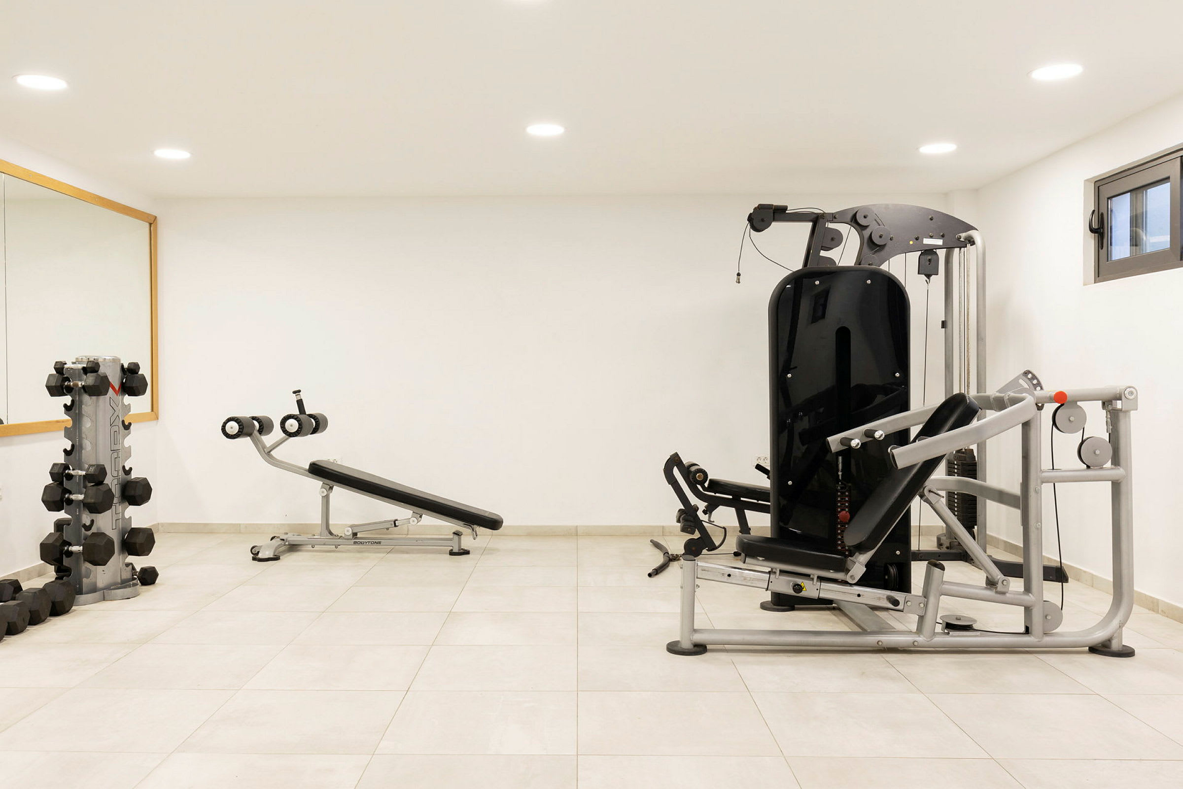 Et fitnessrum med træningsmaskiner og vægte. (AI-genereret tekst)