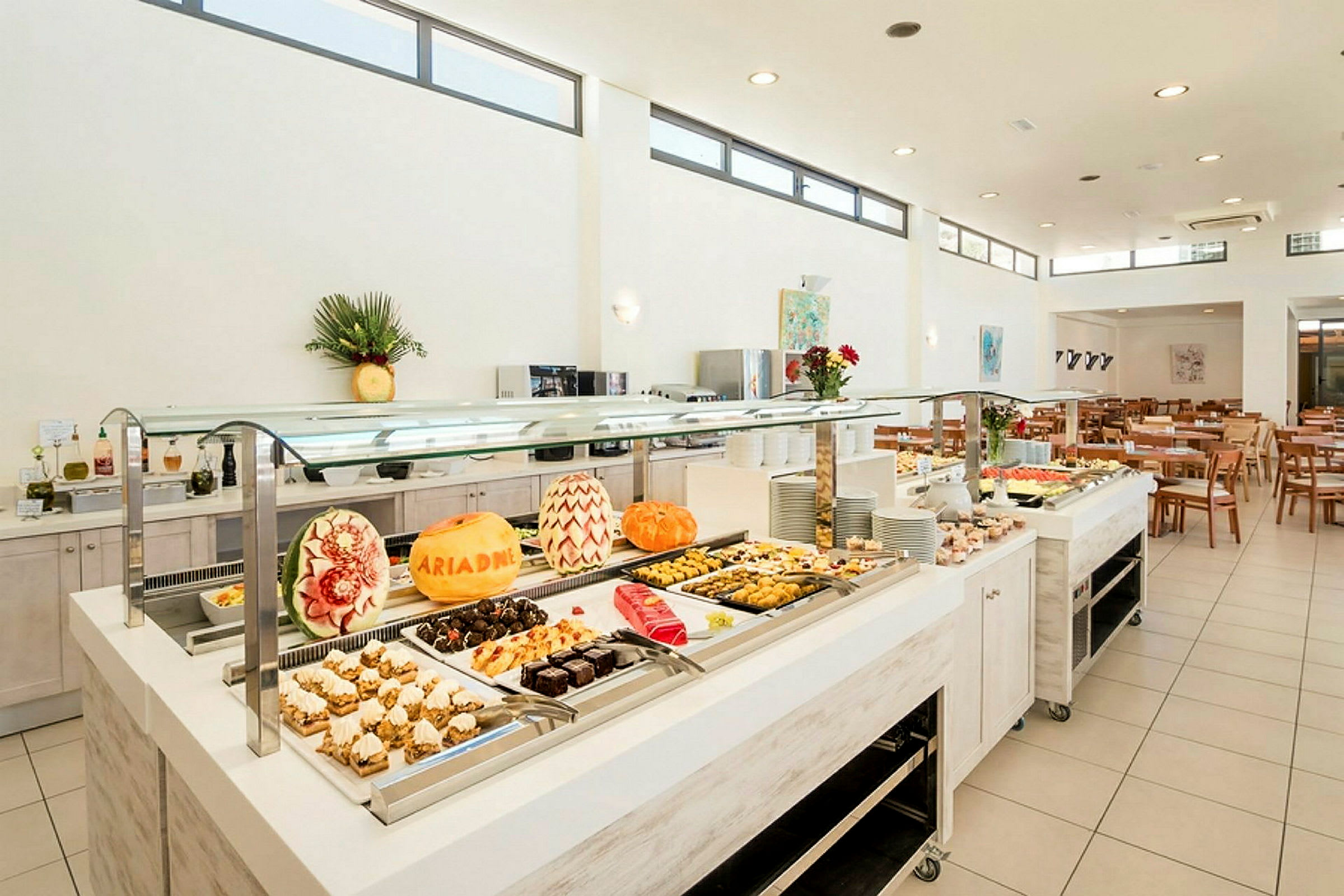 Buffet med dekorerede meloner og et udvalg af desserter. (AI-genereret tekst)