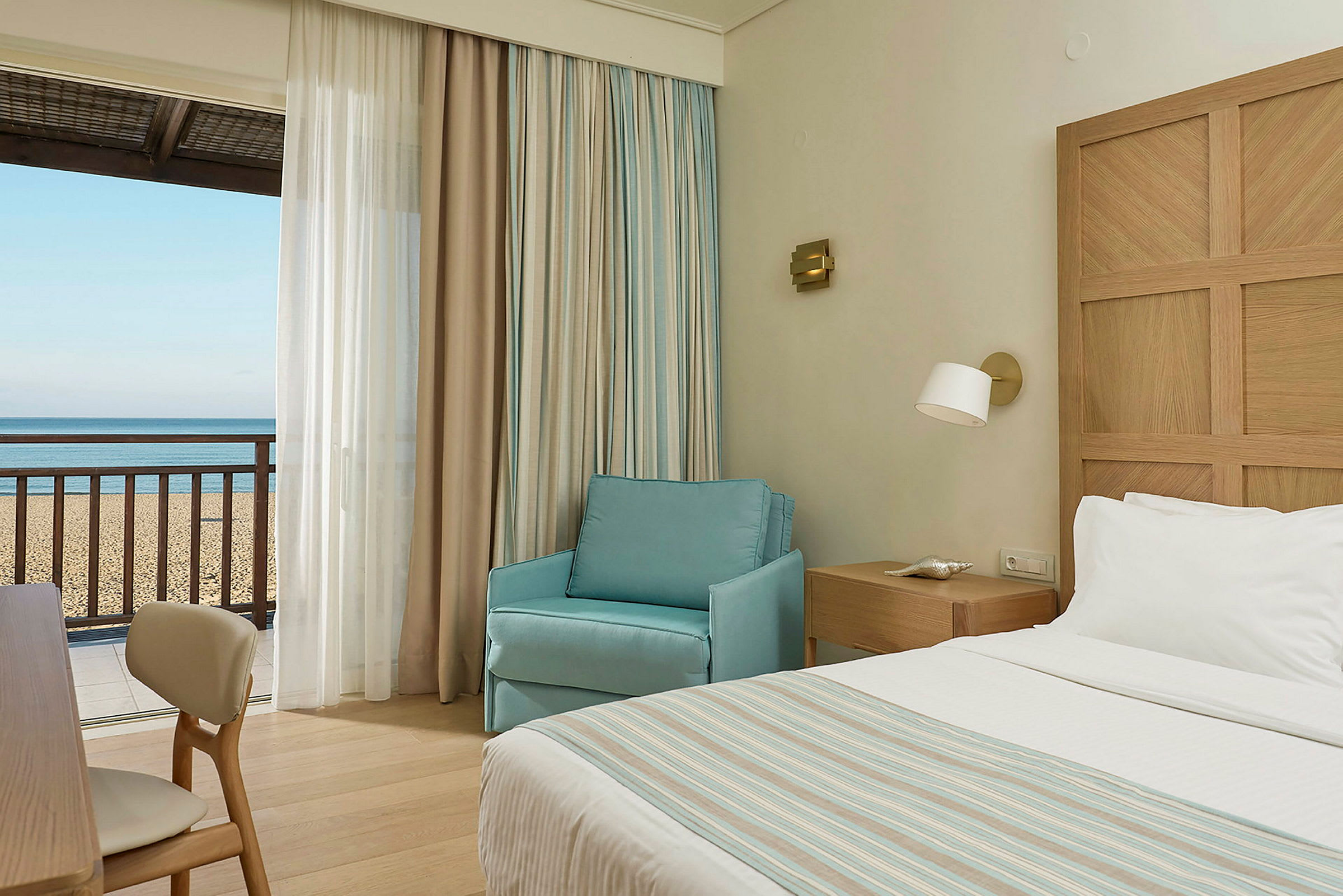 Hotelværelse med udsigt til sandstrand og hav. (AI-genereret tekst)