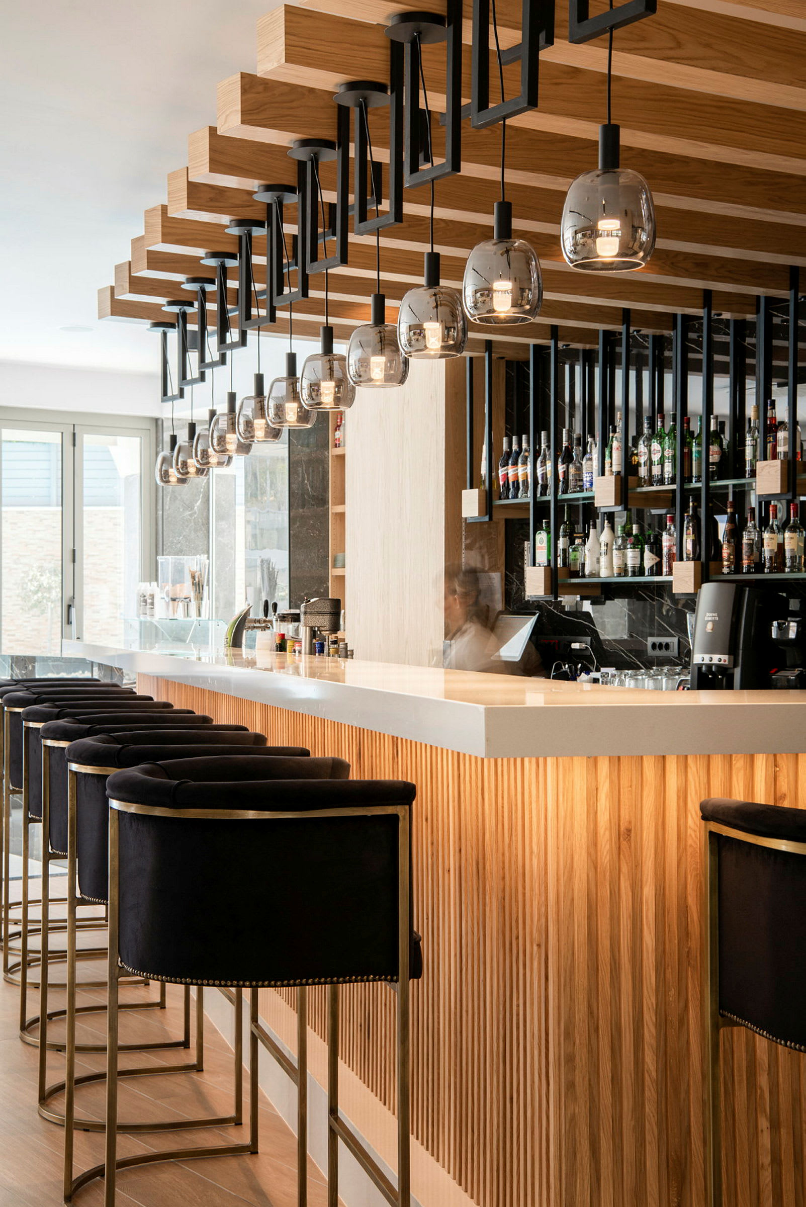 Moderne designet hotelbar med siddepladser og hylder med flasker. (AI-genereret tekst)